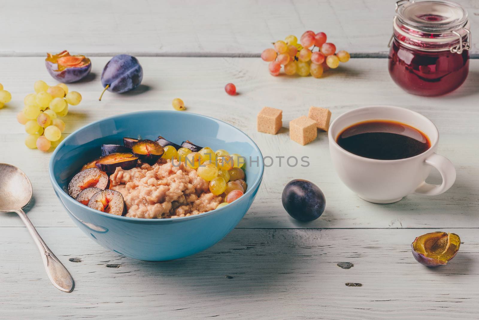 Porridge with fresh plum, green grapes and cup of coffee. by Seva_blsv