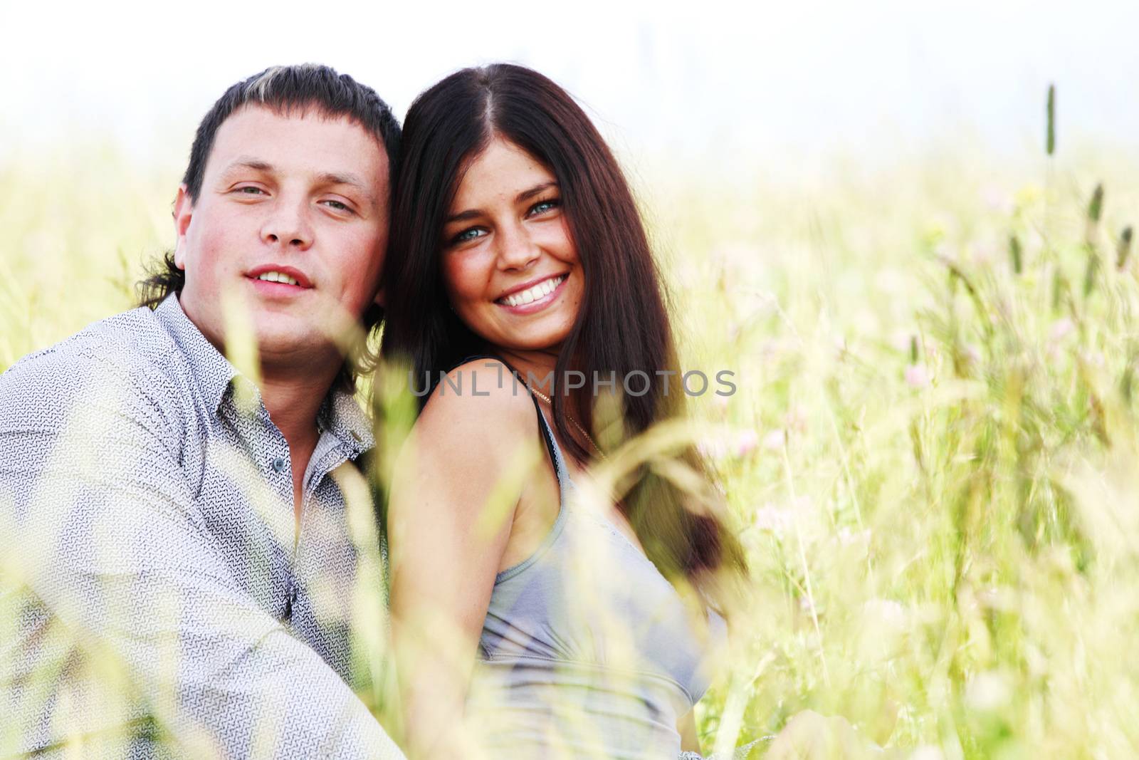 Happy young couple outdoors, two lovers on grass field