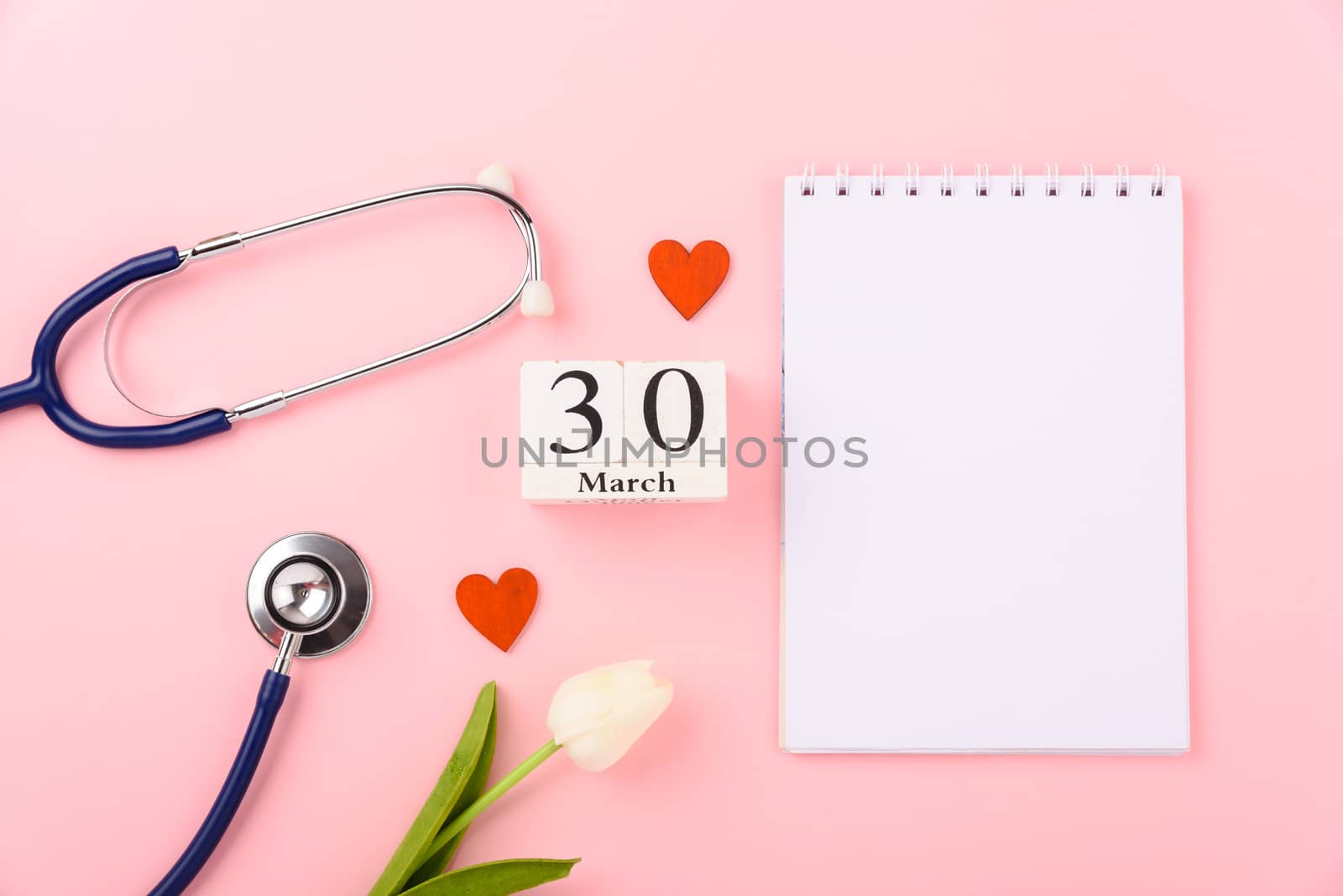 Doctor's Day concept, flat lay top view, equipment medical red heart stethoscope and note book on pink background, care patient in hospital with copy space for text