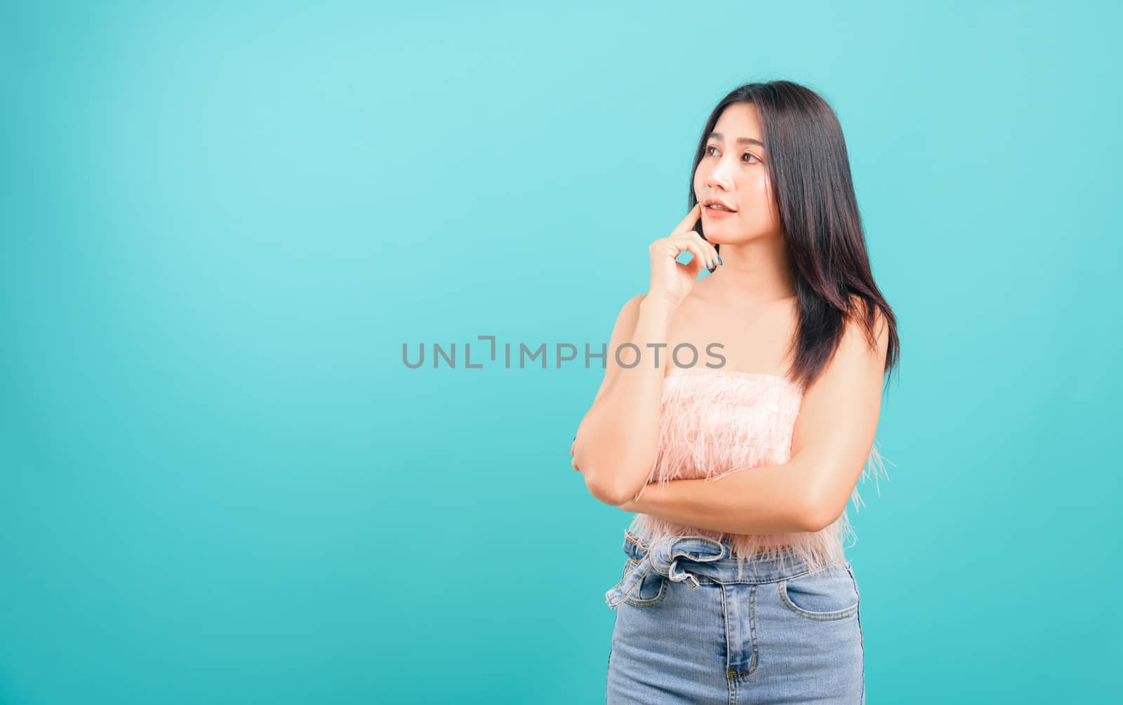 Portrait asian beautiful woman smiling her standing thinking looking on blue background, with copy space for text
