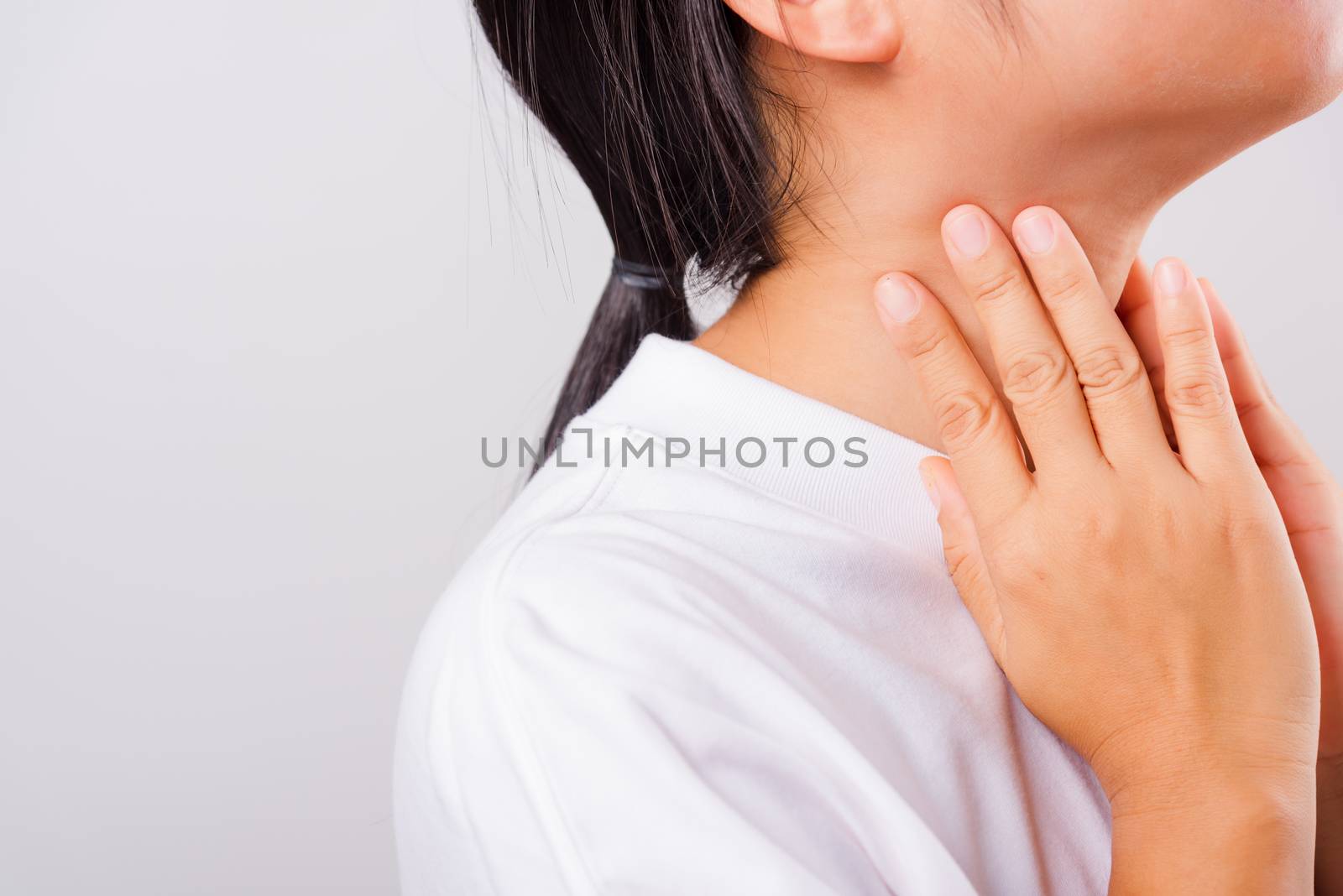 Asian beautiful woman Sore Throat or thyroid gland problem her useing Hand Touching Ill Neck on white background with copy space, Medical and Healthcare concept