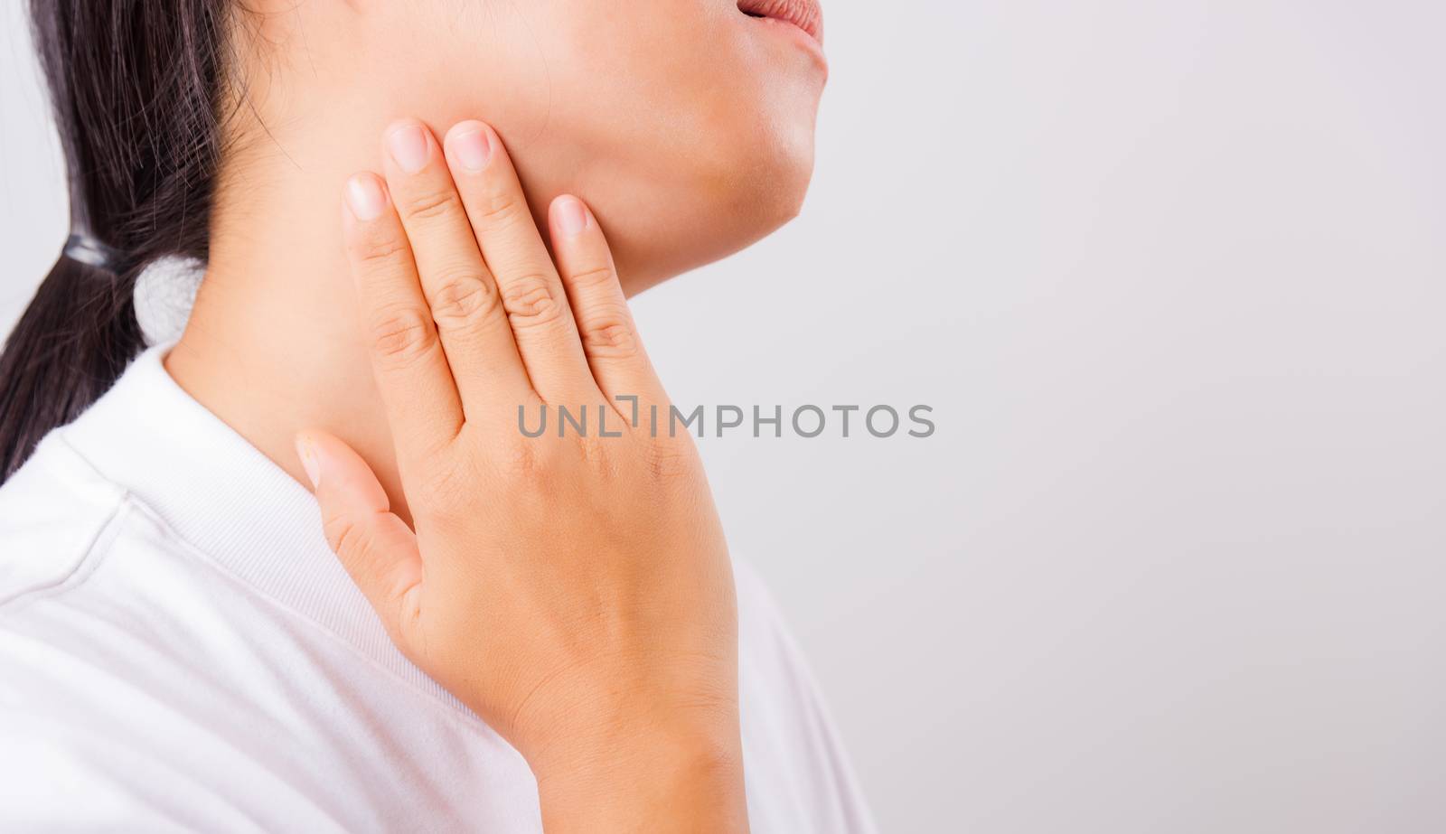 Asian beautiful woman Sore Throat or thyroid gland problem her useing Hand Touching Ill Neck on white background with copy space, Medical and Healthcare concept