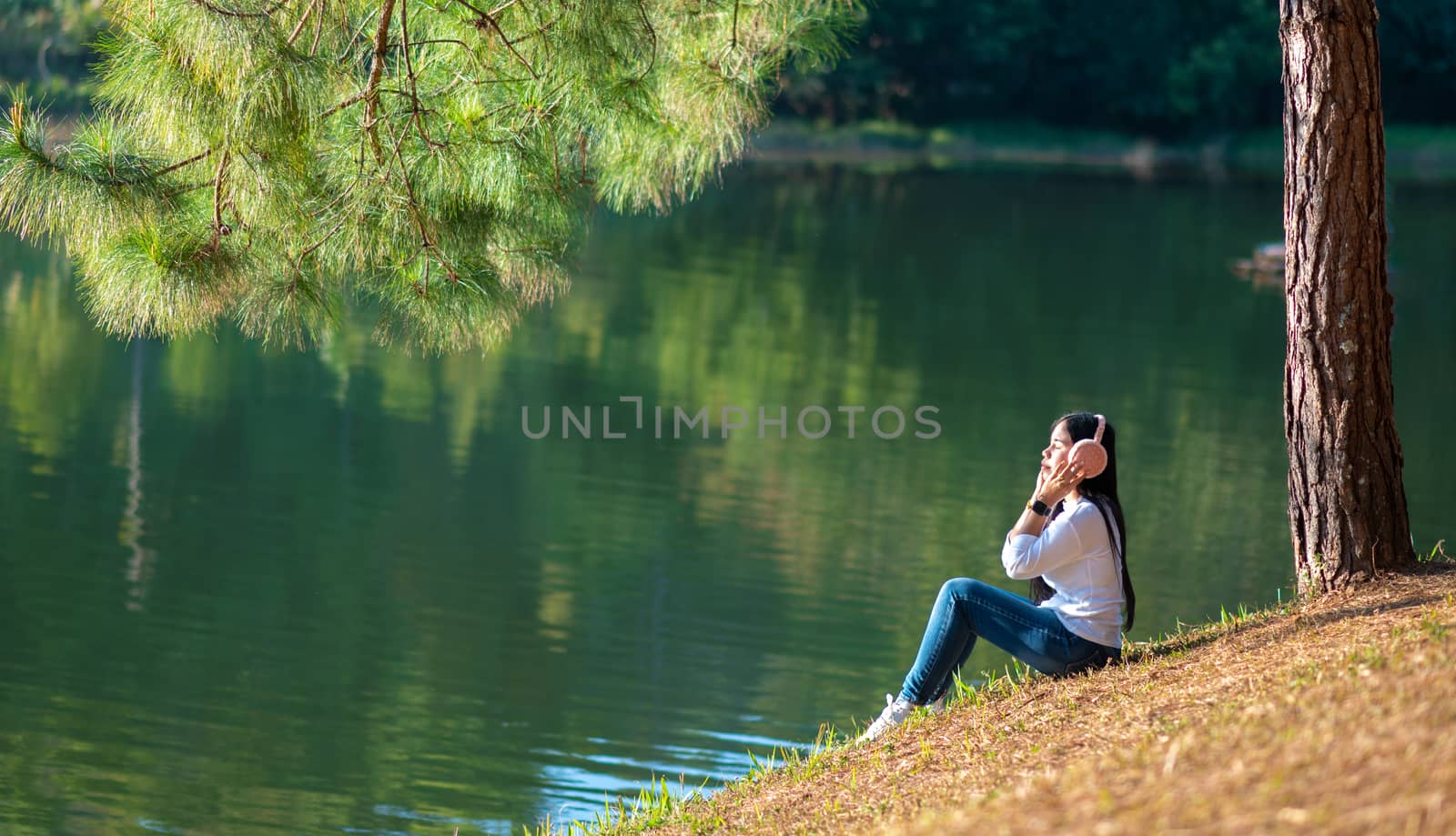 Young people are happily listening to music in their headphones in the midst of nature and the warm light of the morning.