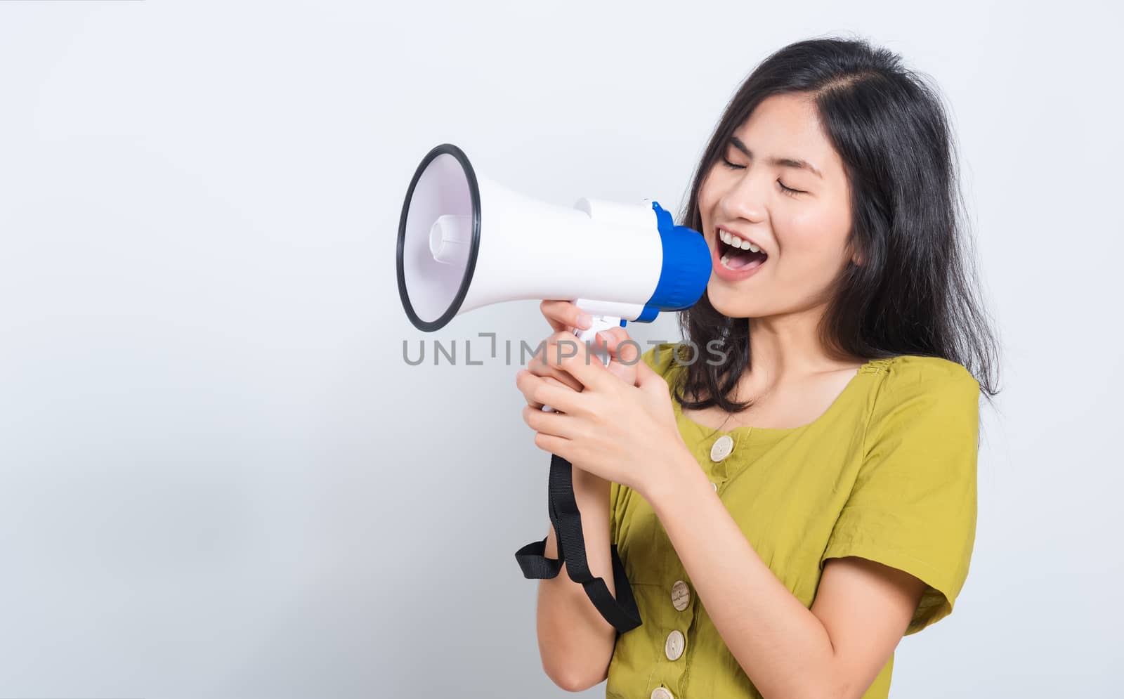 Portrait Asian beautiful young woman standing smile holding and shouting into megaphone looking to space, shoot the photo in a studio on a white background, There was copy space