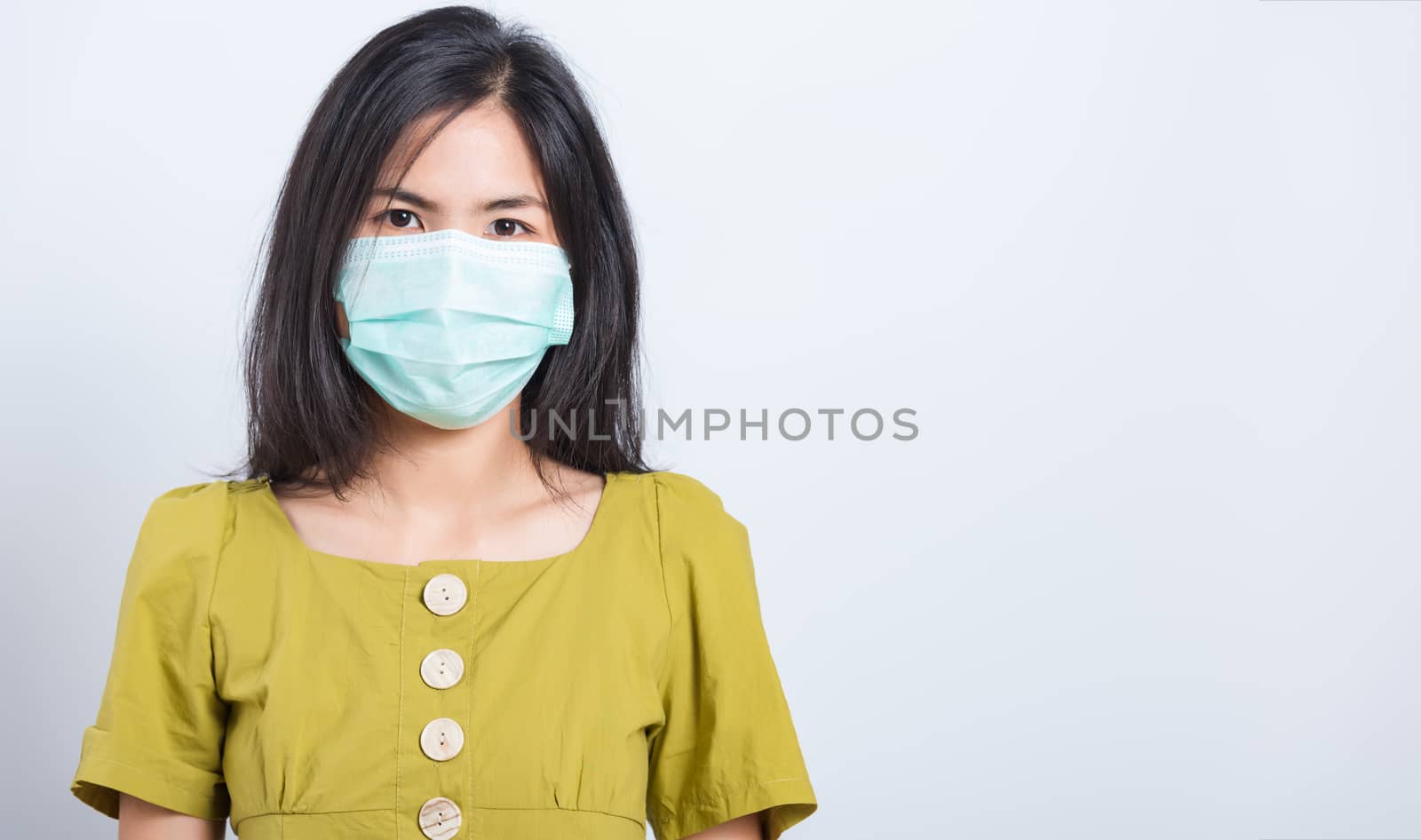 Portrait Asian beautiful happy young woman wearing face mask protects filter dust pm2.5 anti-pollution, anti-smog and air pollution on a white background, with copy space