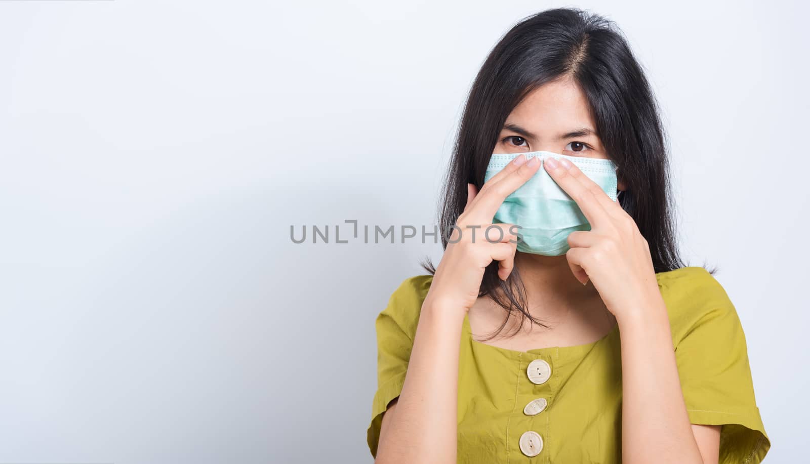 Portrait Asian beautiful happy young woman wearing face mask protects filter dust pm2.5 anti-pollution, anti-smog and air pollution on a white background, with copy space