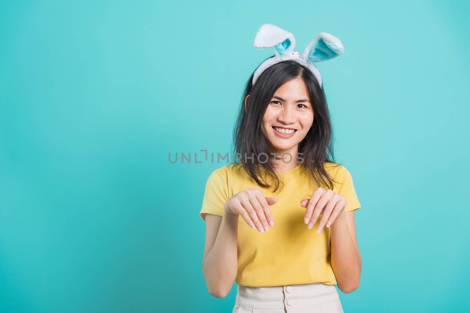 woman smile white teeth wear yellow t-shirt standing with bunny  by Sorapop