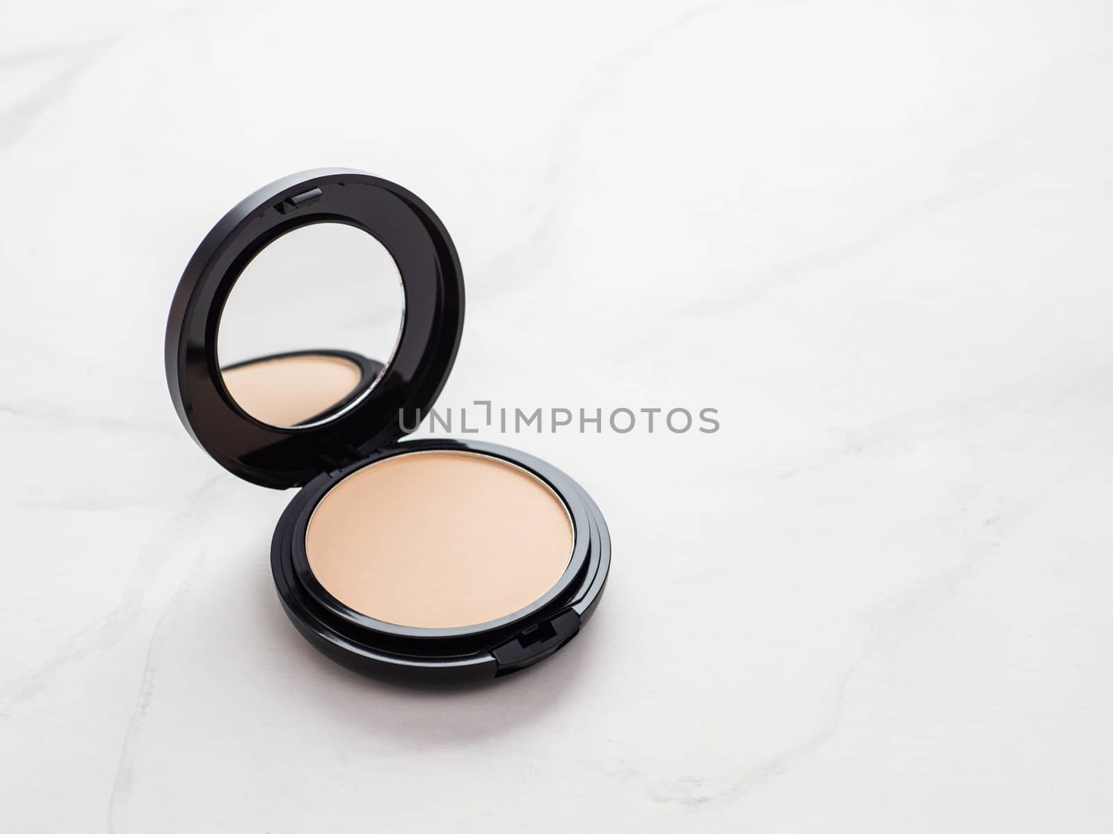 Compact powder on white marble, copy space by fascinadora