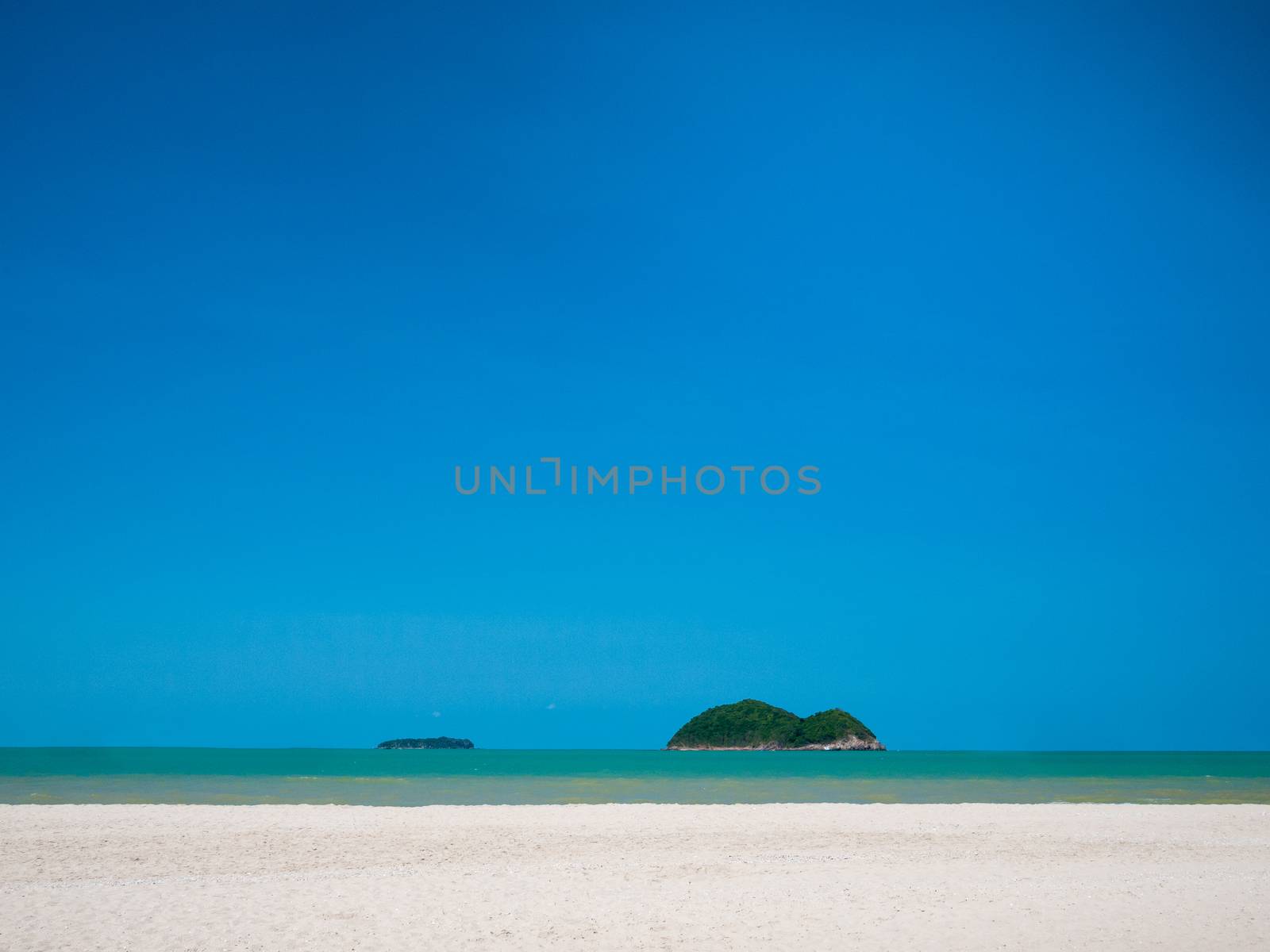 White sand beach with blue sky over sea by hadkhanong