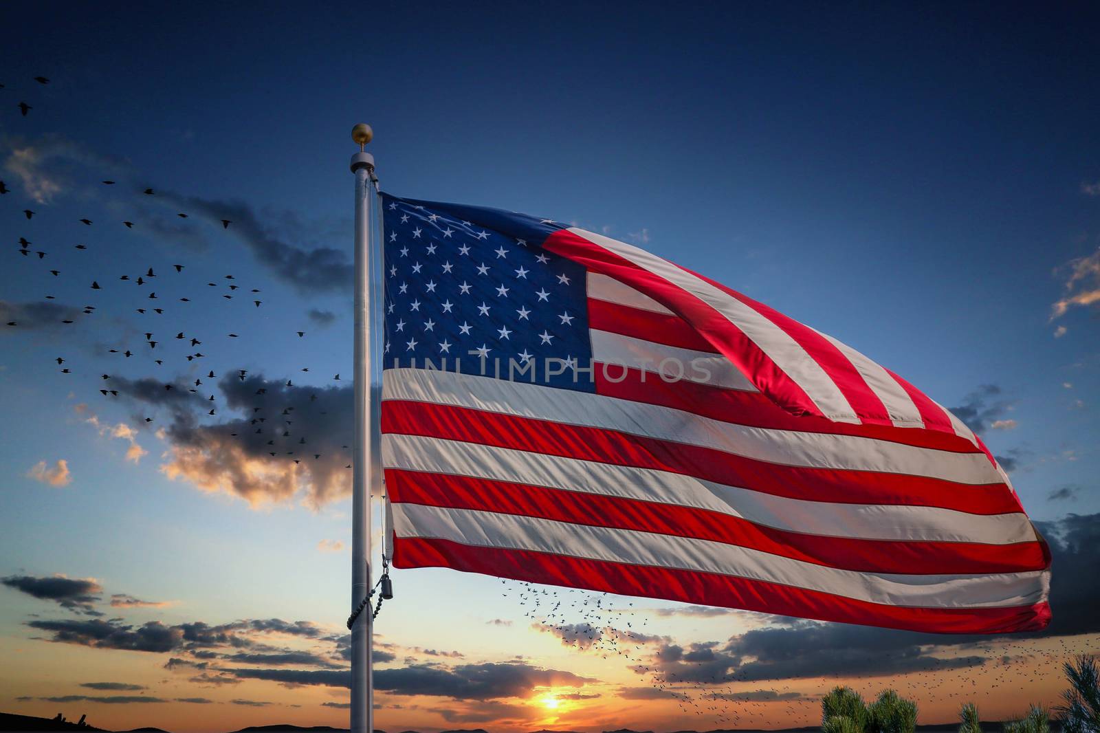 An American flag blowing in the wind under clear blue skies