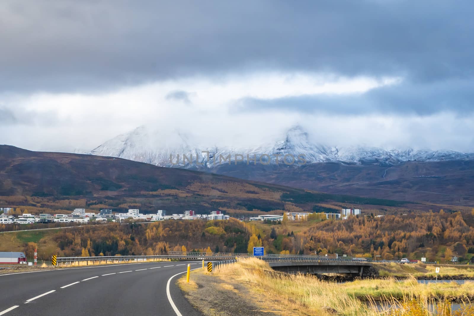 Akureyri biggest city of the North in Iceland in front of snow covered mountains in autumn by MXW_Stock