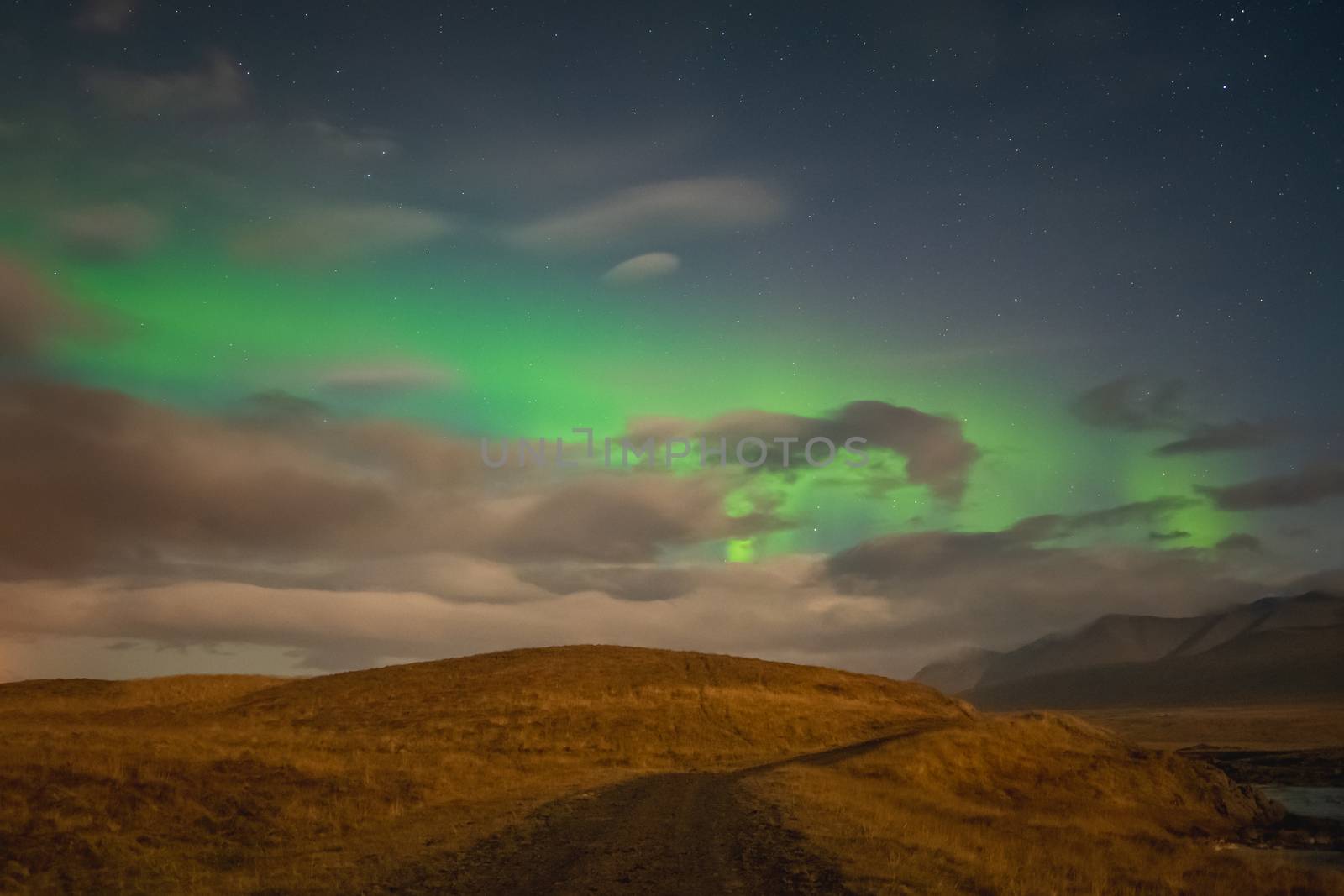 Aurora Borealis in Iceland northern lights bright beams over hiking path by MXW_Stock
