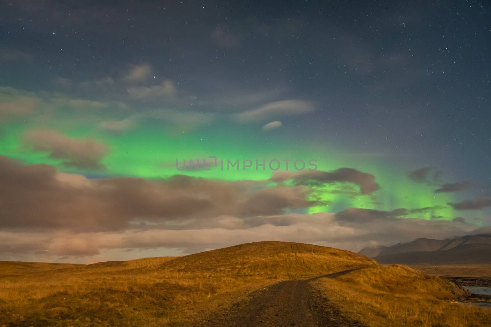 Aurora in Iceland northern lights bright beams over clouds during full moon