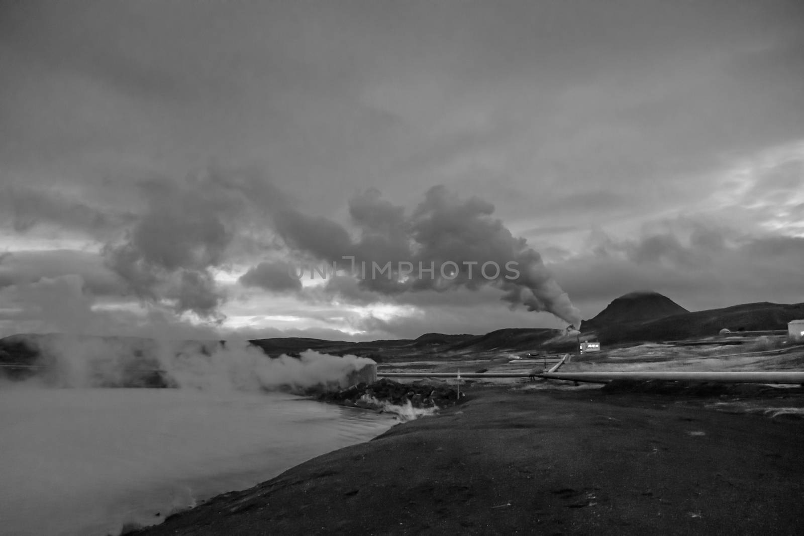 Blue Lake in Iceland geothermal hot spring turquoise water steam pipelines in black and white