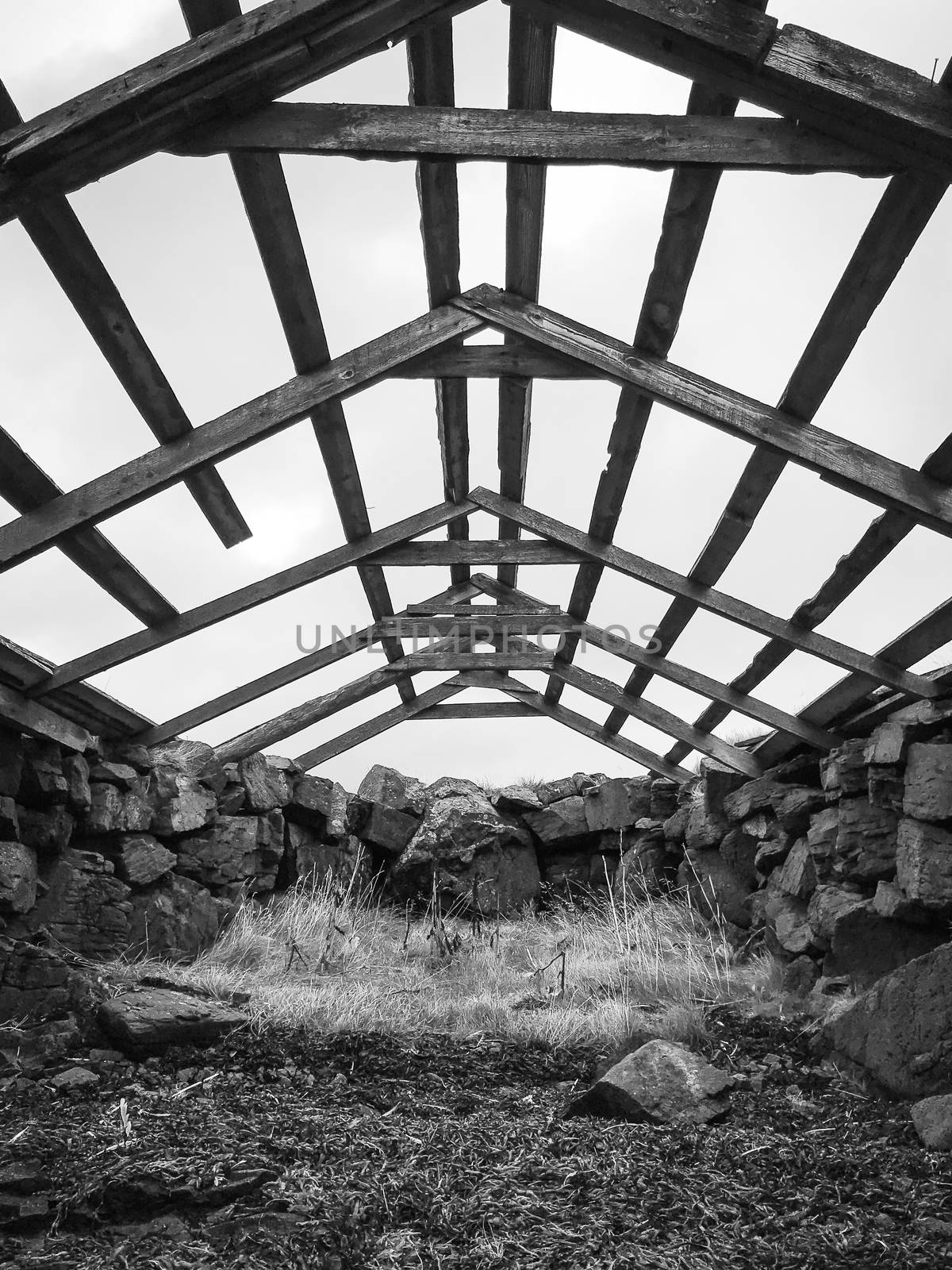 Boat house in Iceland old structure in Westfjords roof blown away in black and white by MXW_Stock