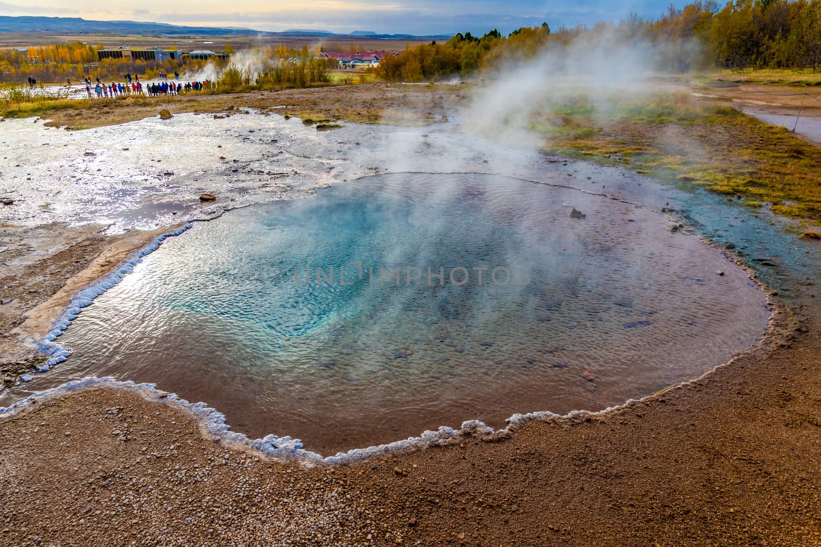 Geysir Golden Circle in Iceland deep blue water in geothermal pool steaming hot salty crust Blesi pool