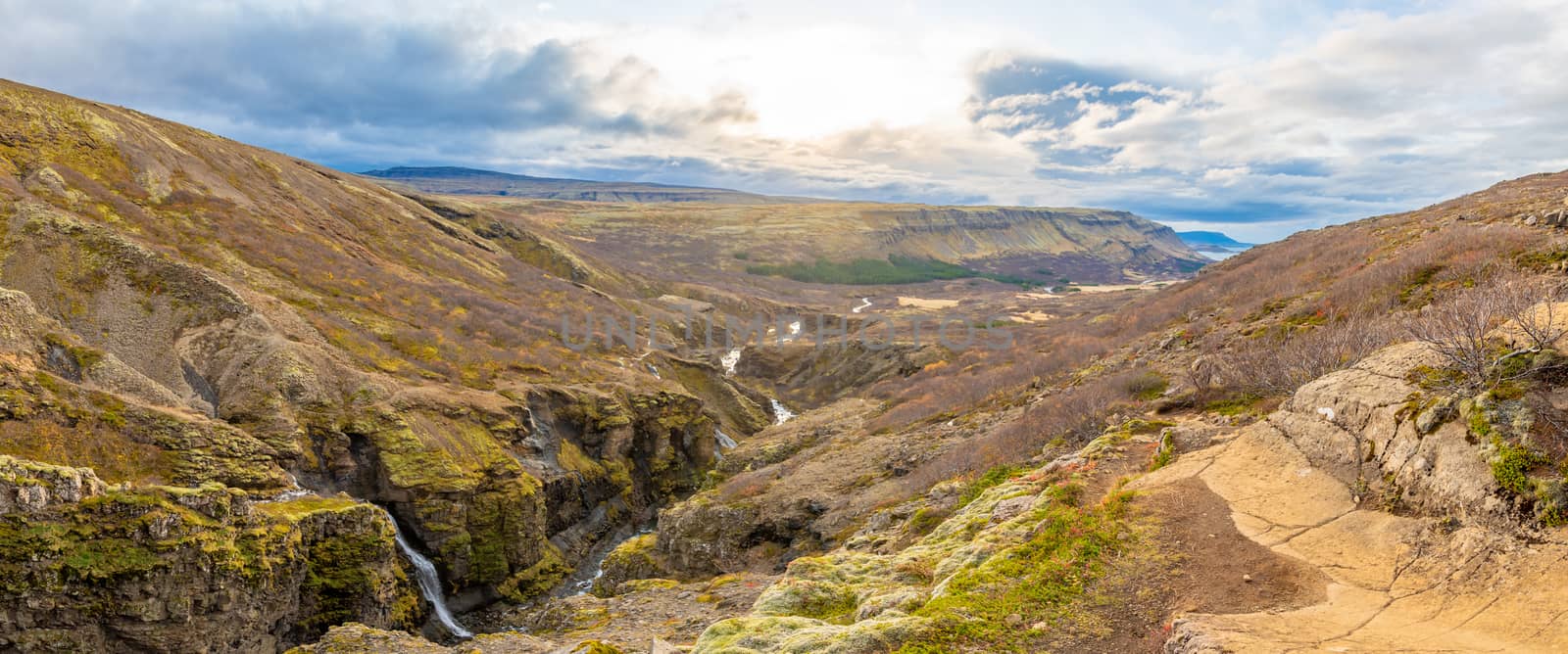 Glymur waterfall in Iceland panorama of gorge behind fall and river leading downwards to lake by MXW_Stock