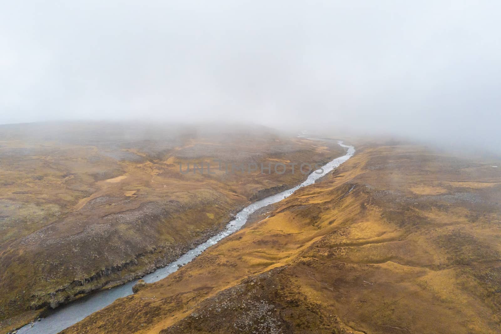 Highlands of Iceland aerial shot of sparse vegetation under low clouds in fall