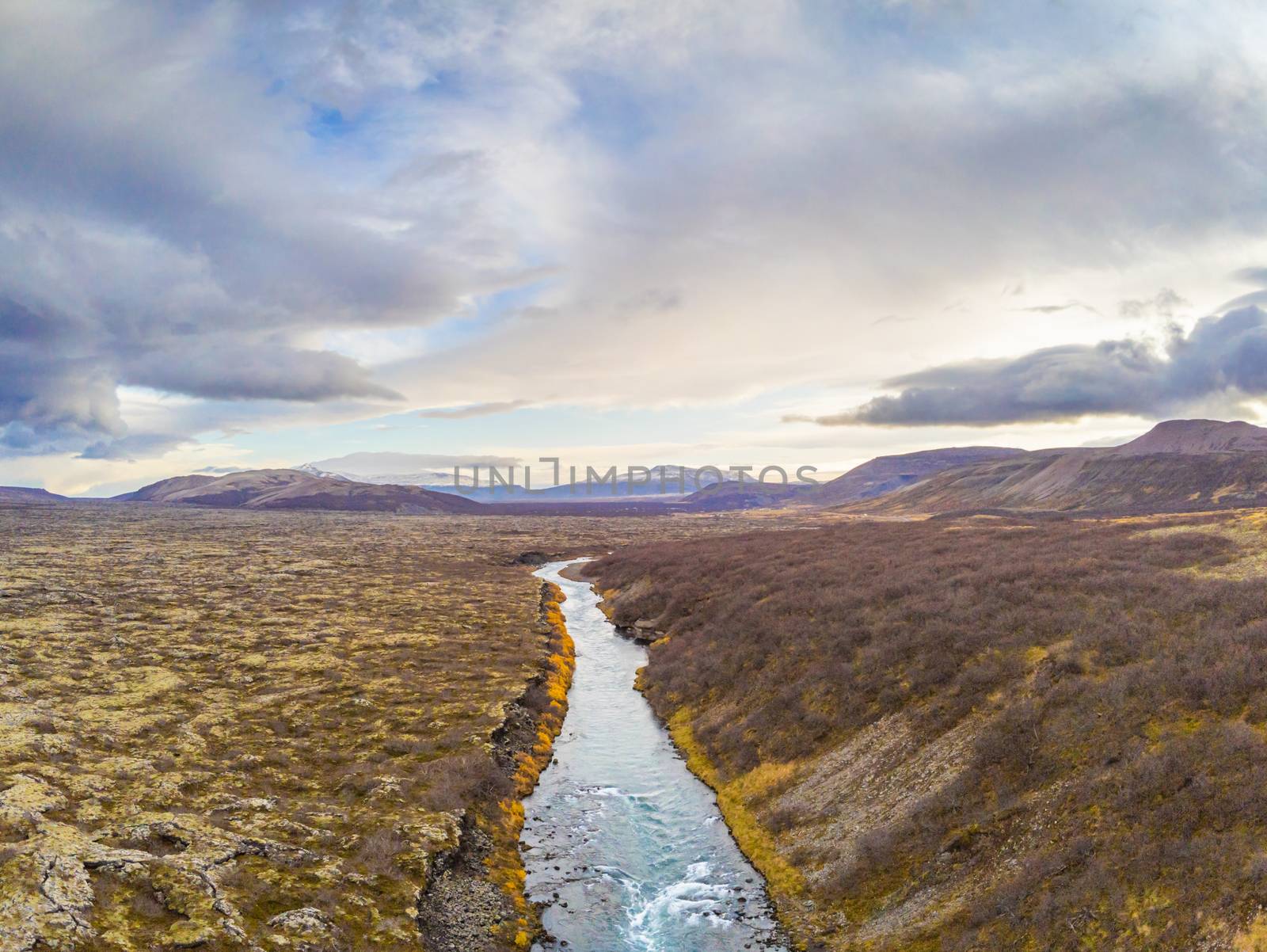 Hraunfossar series of waterfalls barnafoss aerial image of turquoise water next to lava field and the highlands