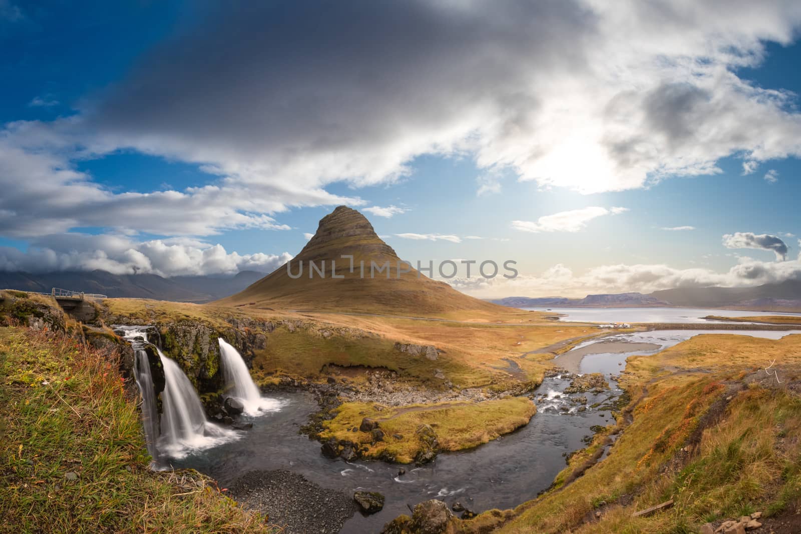Kirkjufell in Iceland Kirkjufellsfoss waterfall and famous mountain under beautiful sunny and blue sky