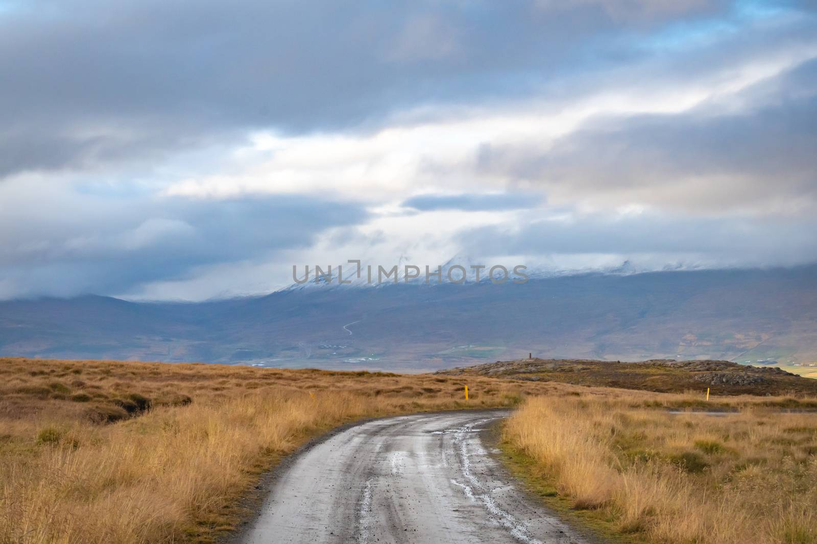 Mountain pass towards Akureyri in Iceland snow covered mountain tops disappearing in clouds by MXW_Stock
