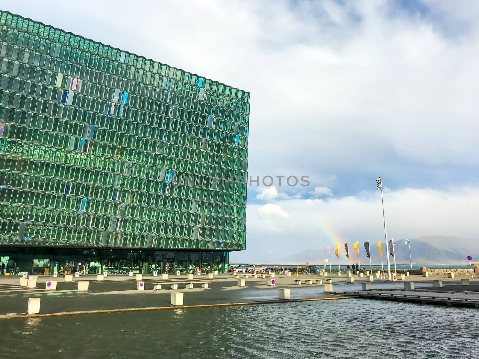 Reykjavik in Iceland Harpa concert hall next to rainbow during rainy day