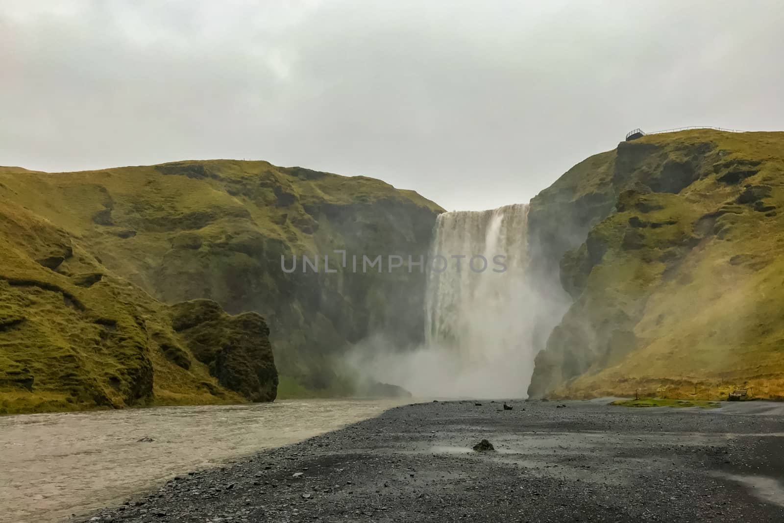 Skogafoss waterfall in Iceland during heavy rainfall and stormy weather by MXW_Stock