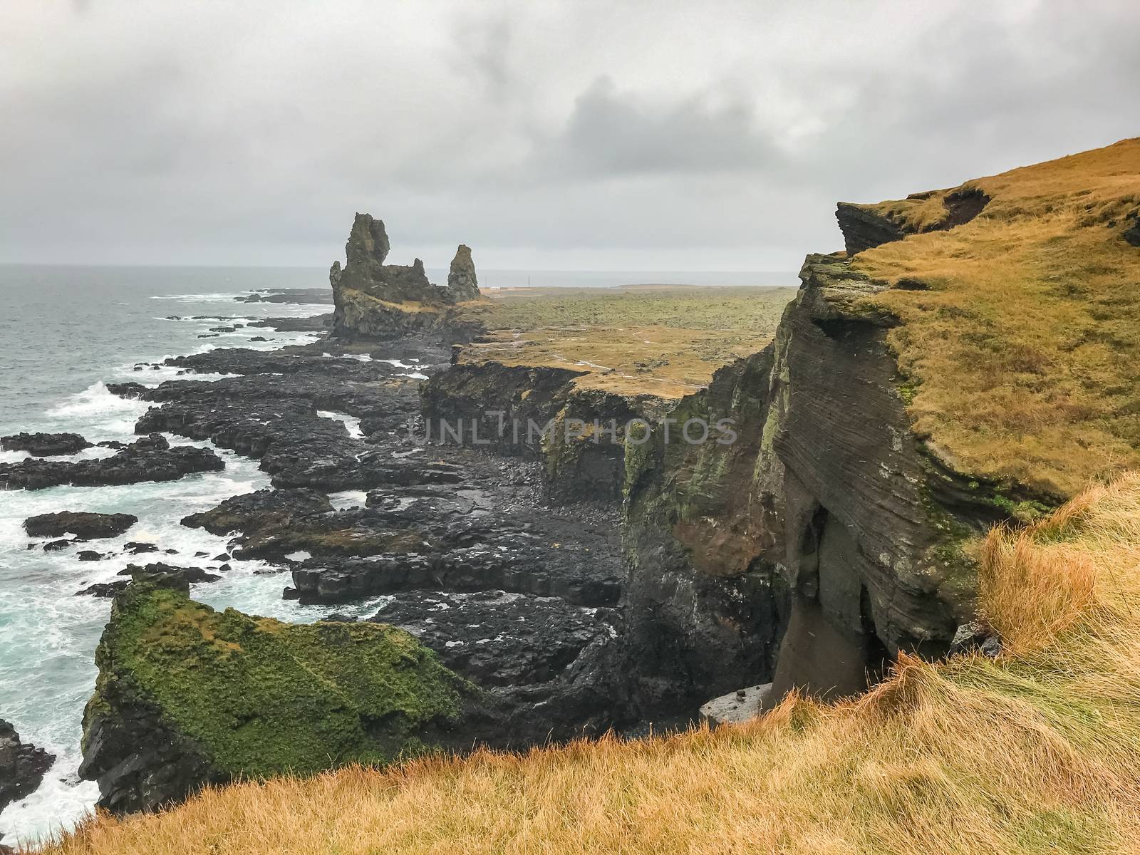 Snaefellsness national park in Iceland Londrangar volcanic basalt towers at steep cliff coast