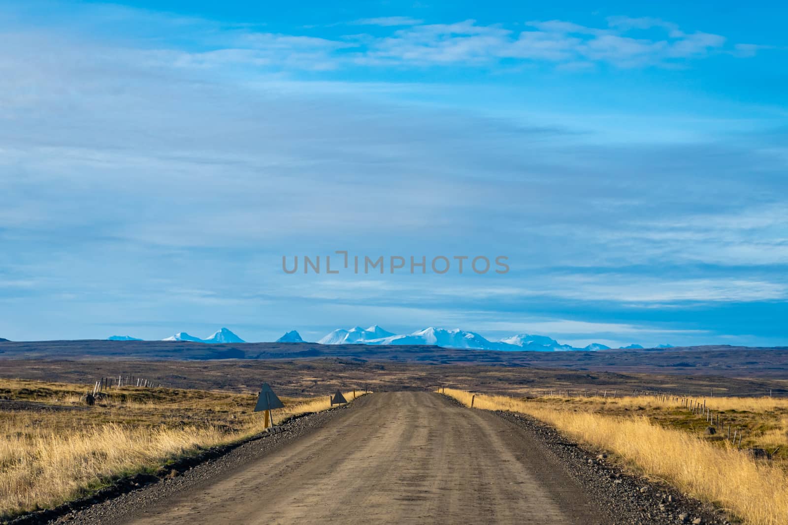 Snaefellsness national park in Iceland scenic landscape and unpaved road in front of snow covered mountains during sunny day by MXW_Stock