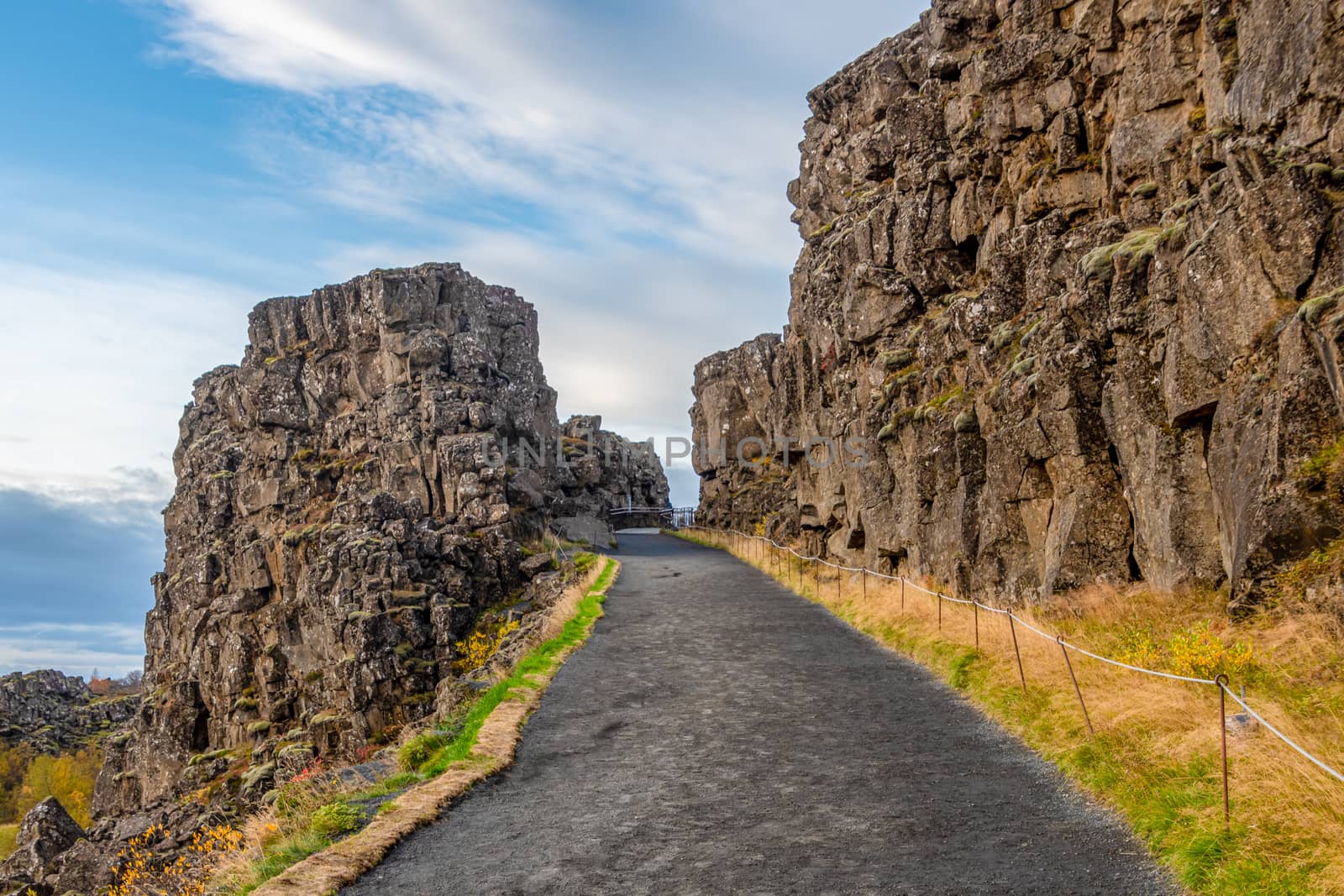 Thingvellir National Park in Iceland during sunny weather hiking path through canyon by MXW_Stock