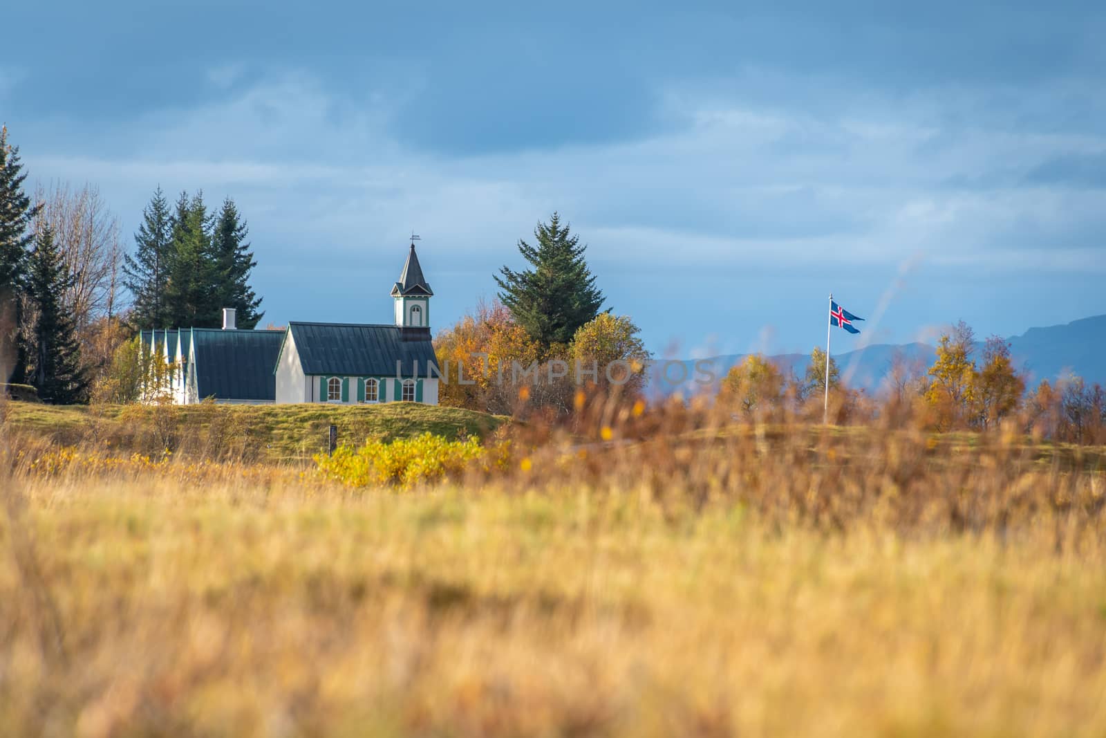 Thingvellir National Park in Iceland wooden church and icelandic flag by MXW_Stock