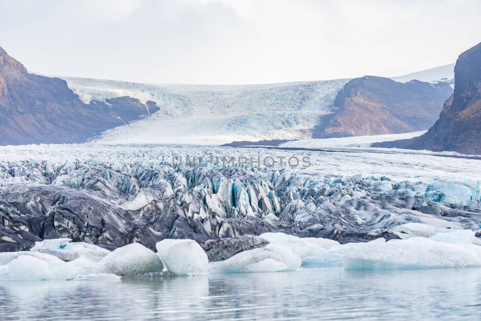 Vatnajoekull glacier in Iceland deep blue ice and layers of ash from volcanic eruptions by MXW_Stock