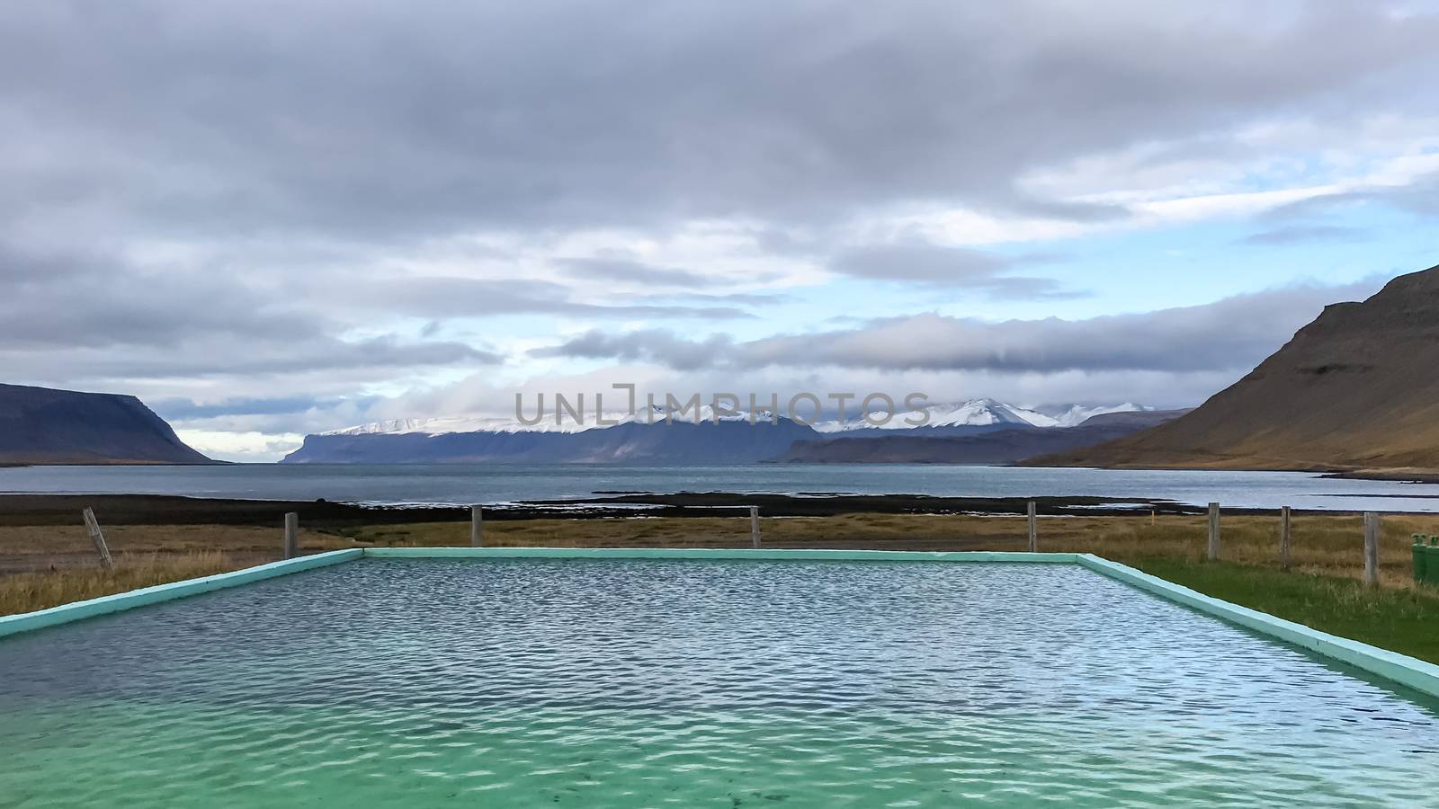 West fjords of Iceland hot spring feeding warm pool with fjord view