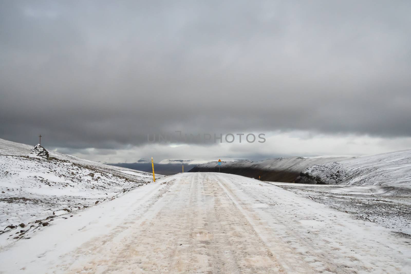 Westfjords of Iceland snow covered mountain pass during autumn and stormy weather by MXW_Stock