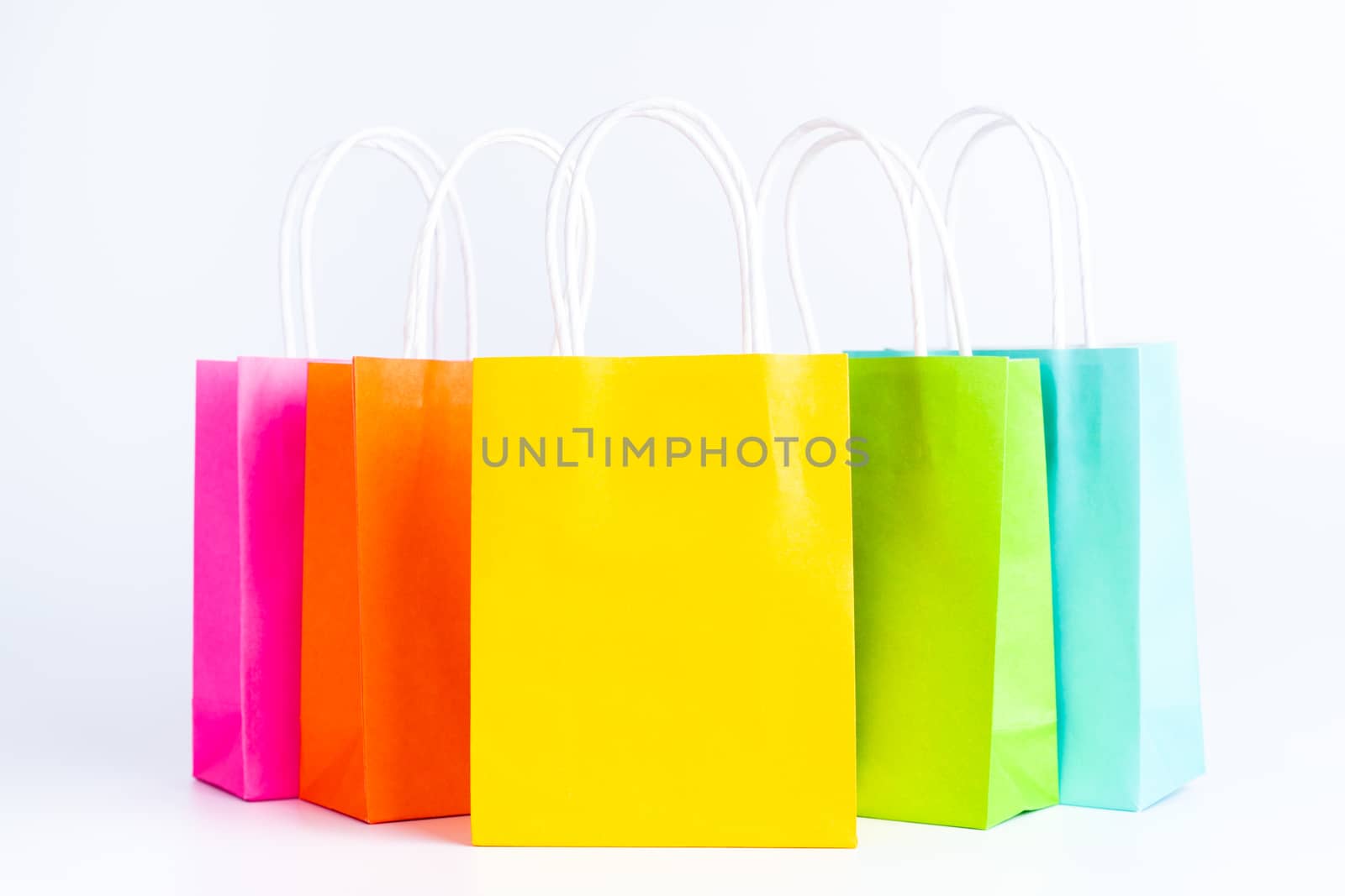 Colorful shopping bags standing in a row isolated on white background