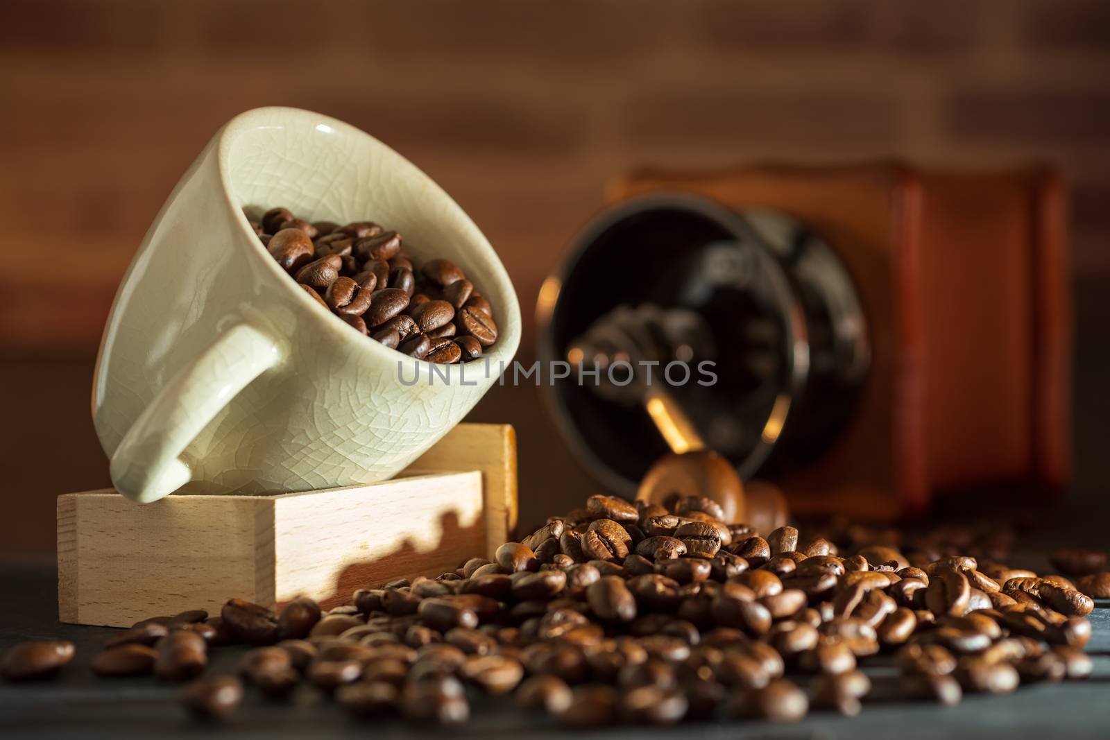 Coffee bean in the white cup and coffee grinder on wooden table. Concept breakfast or coffee time in morning.