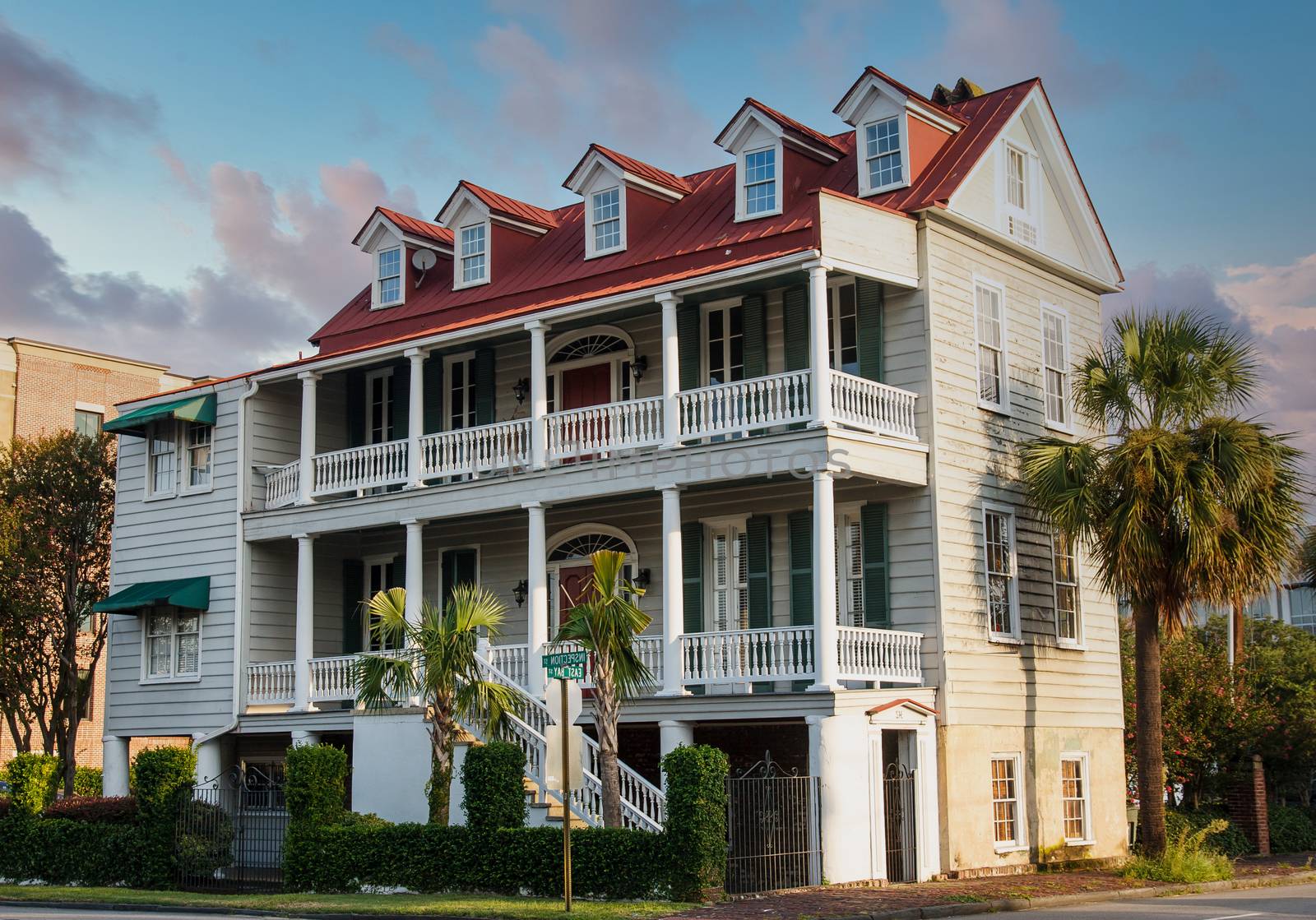 A two story traditional wood home with red roof in Charleston, South Carolina