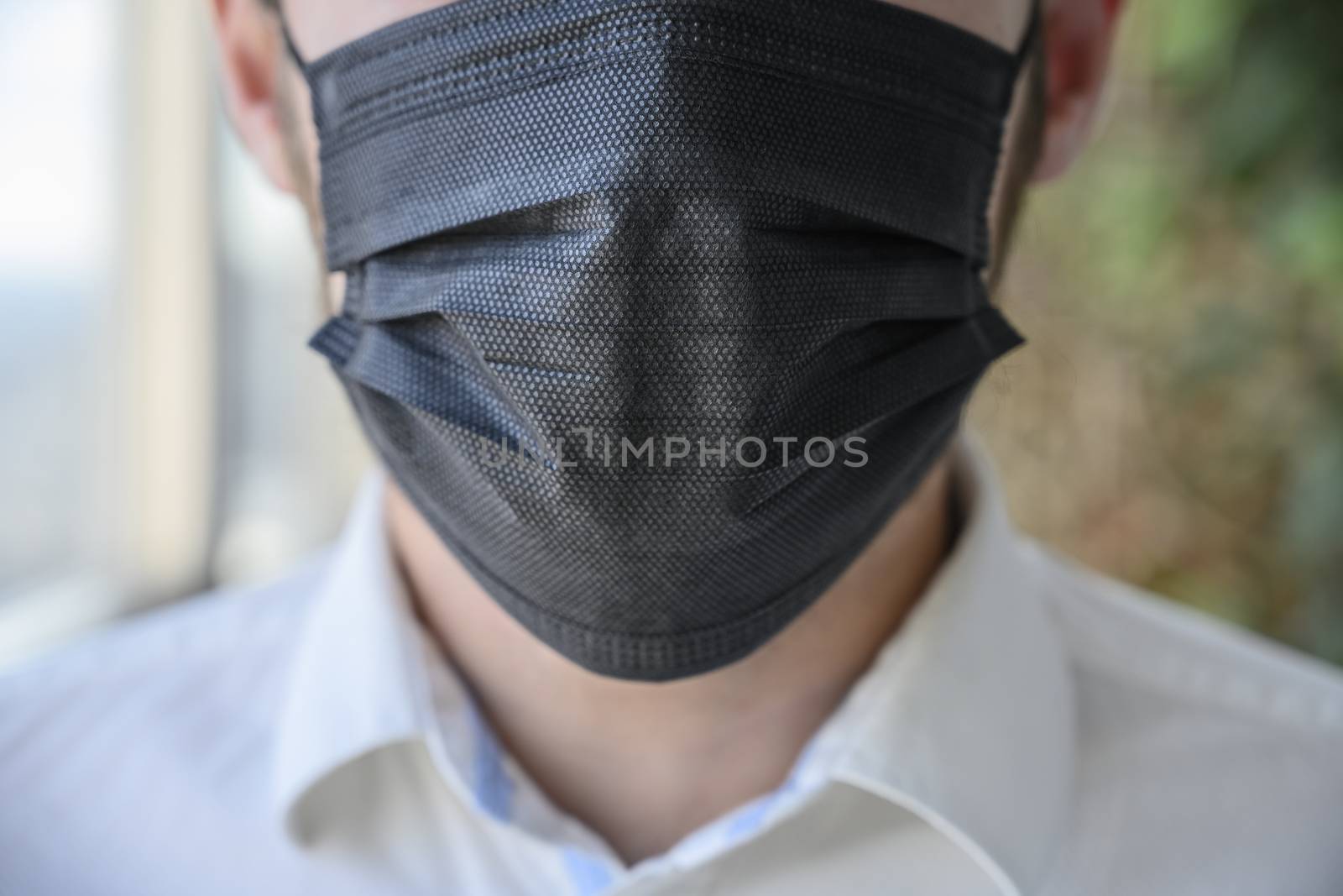 A man wearing a black respiratory mask on his face.