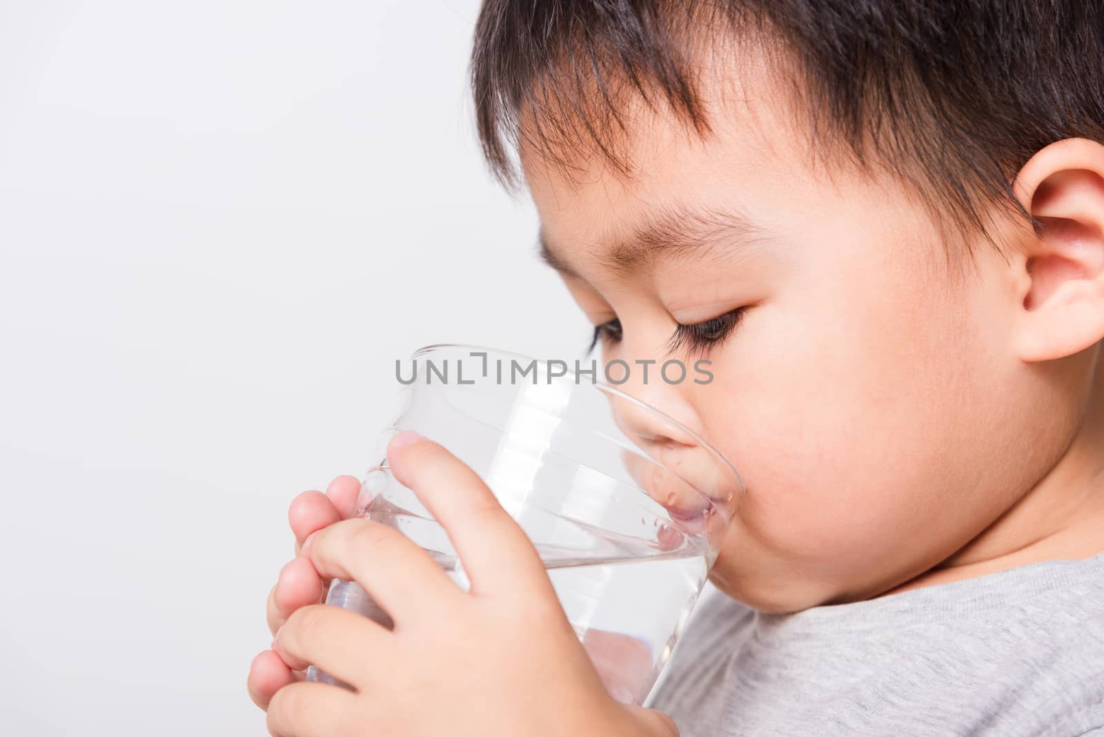 Closeup Asian face, Little children boy drinking water from glas by Sorapop