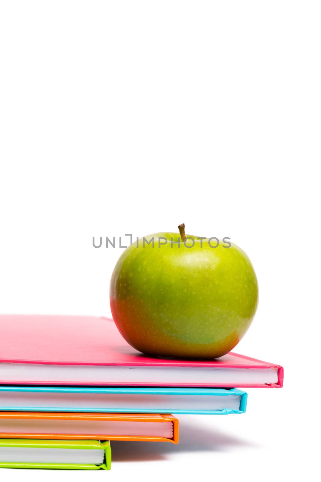 Green apple on notebooks on white background