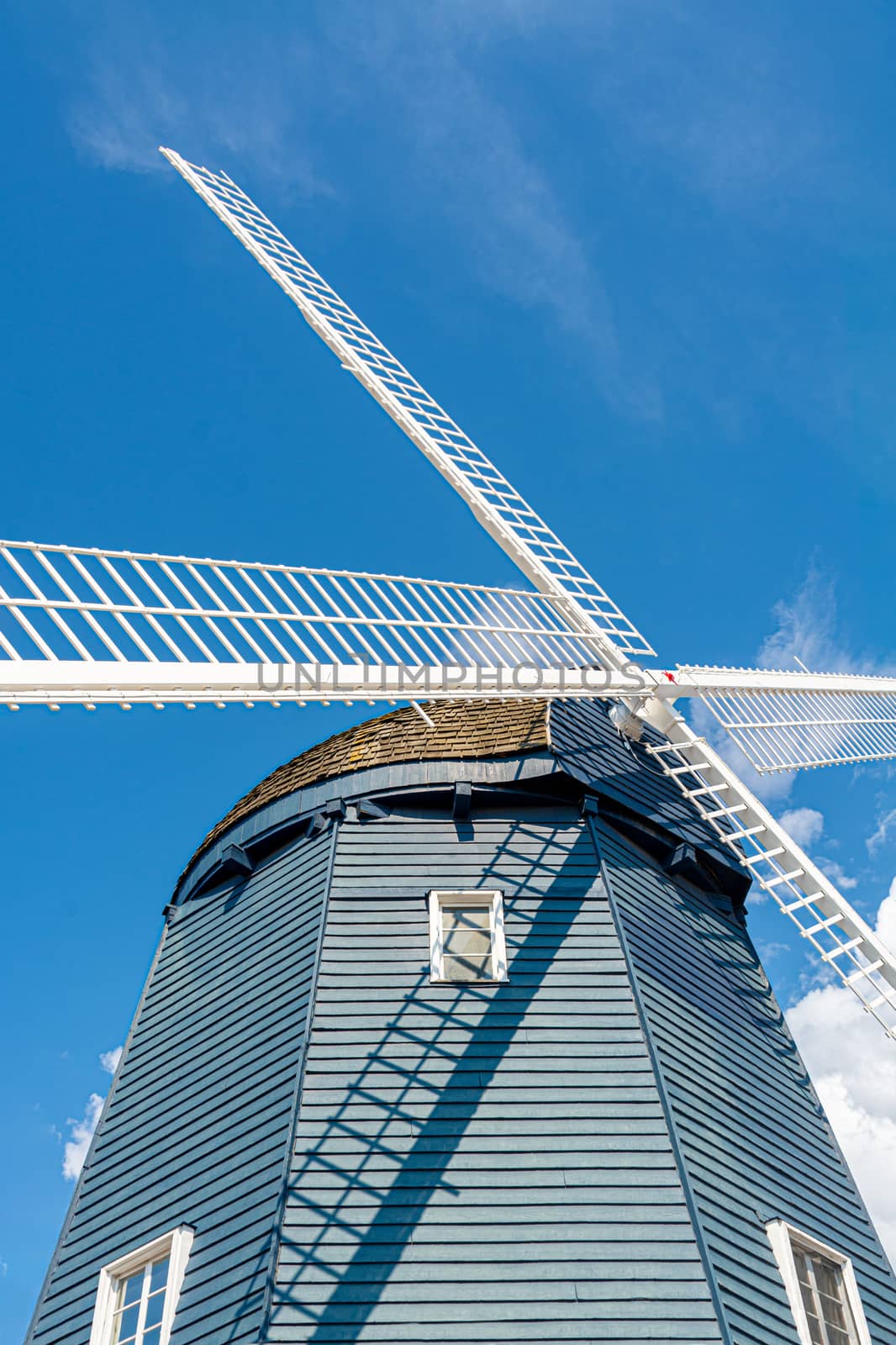 Vintage wind mill decorated with lights on blue sky background