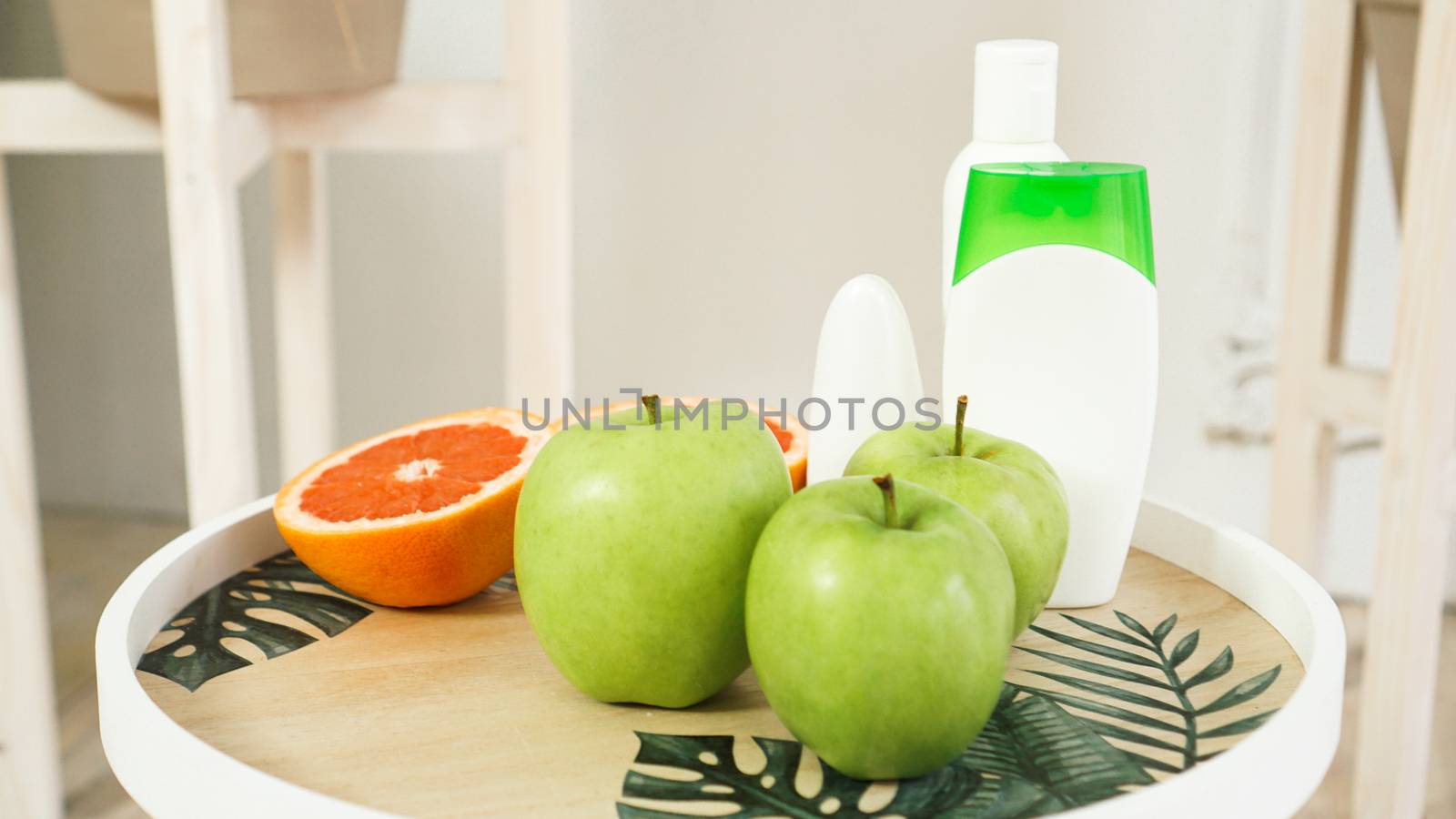 Organic orange and green apples on the natural wooden table. Selective focus. Health food, cosmetic and spa concept
