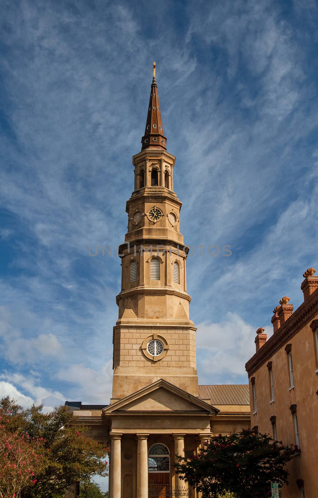 An old brown stone church steeple with clock in Charleston, South Carolina
