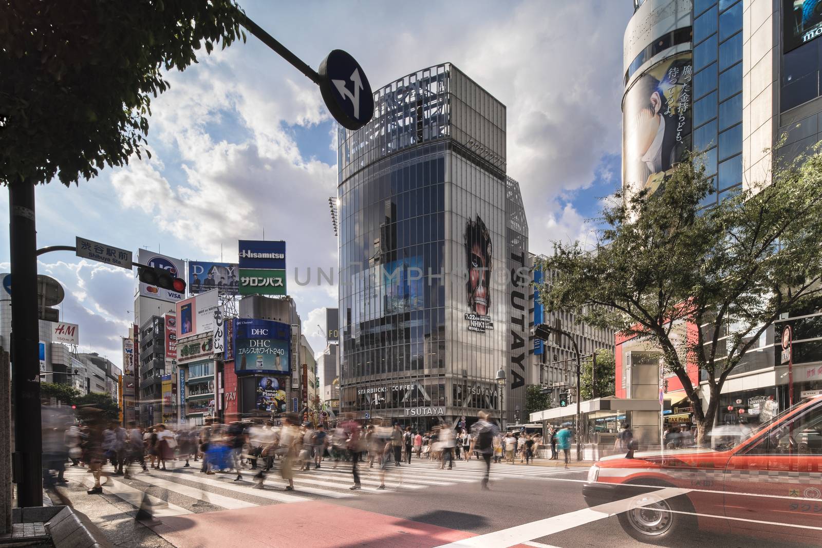 Wide view of the Shibuya Crossing Intersection in front of Shibuya Station on a bright summer day.