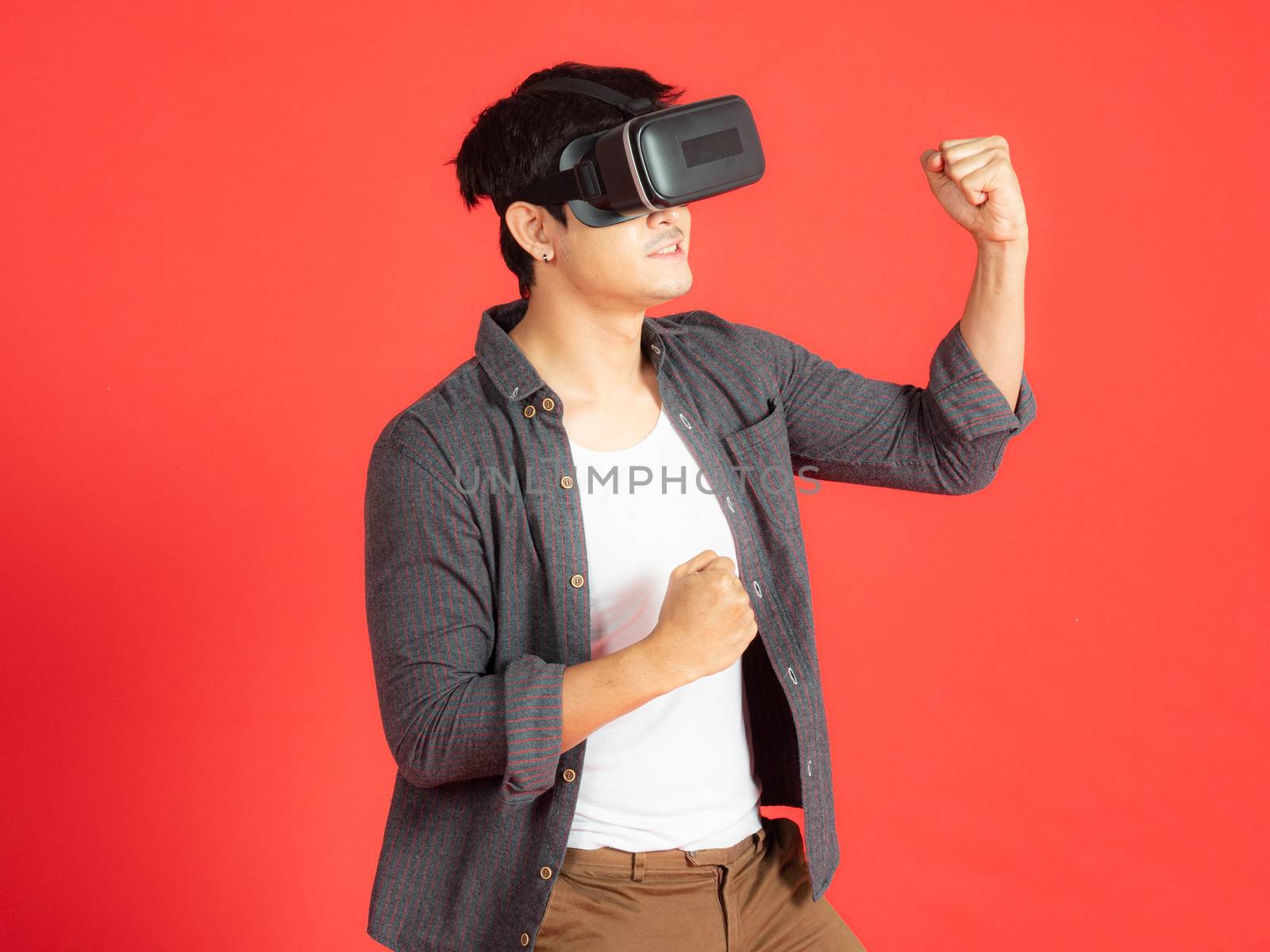 Young Man Wearing VR Headset and exploring another world isolated on red background