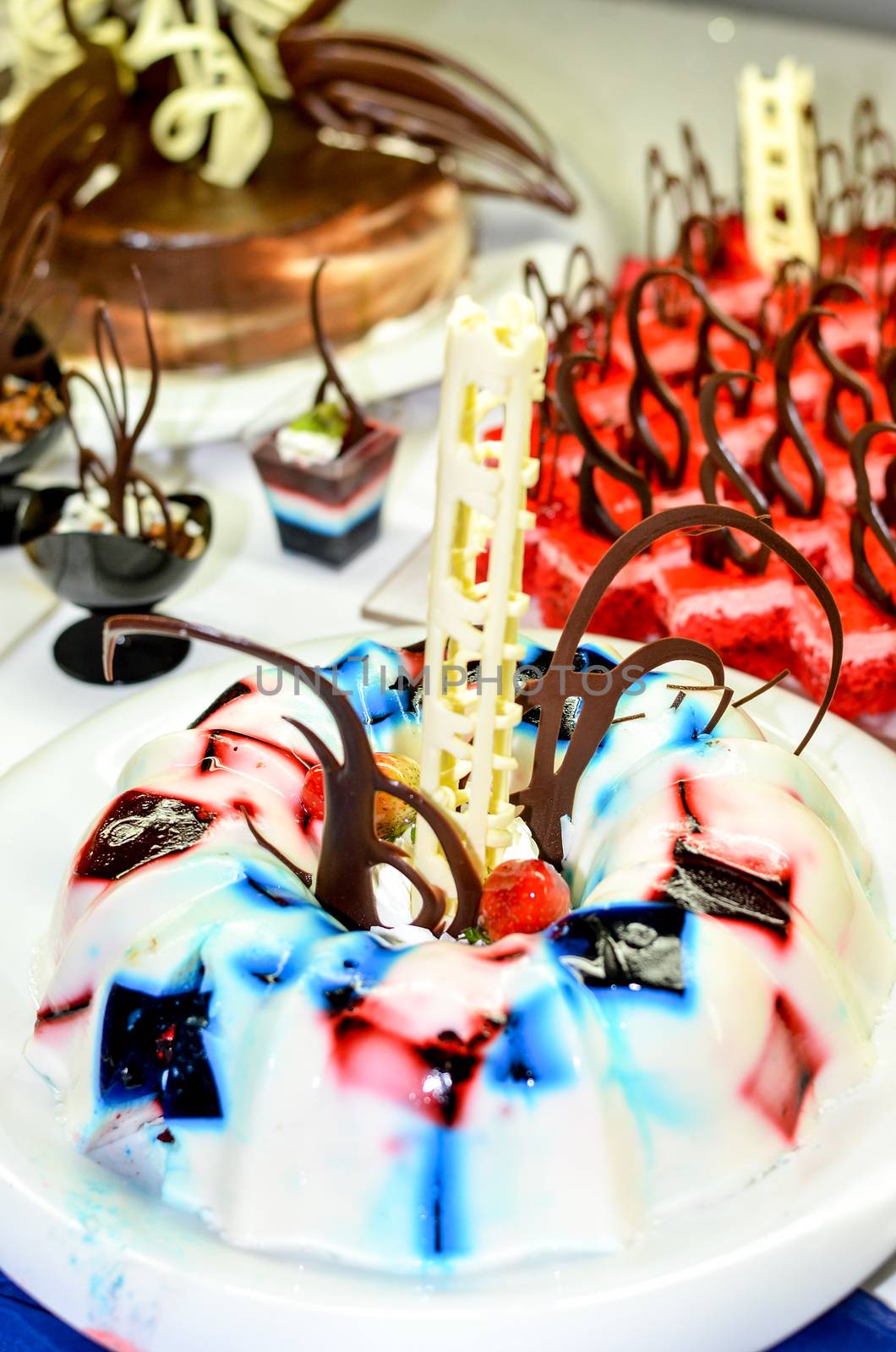 Tray full of cupcakes and slices of cake inside a buffet