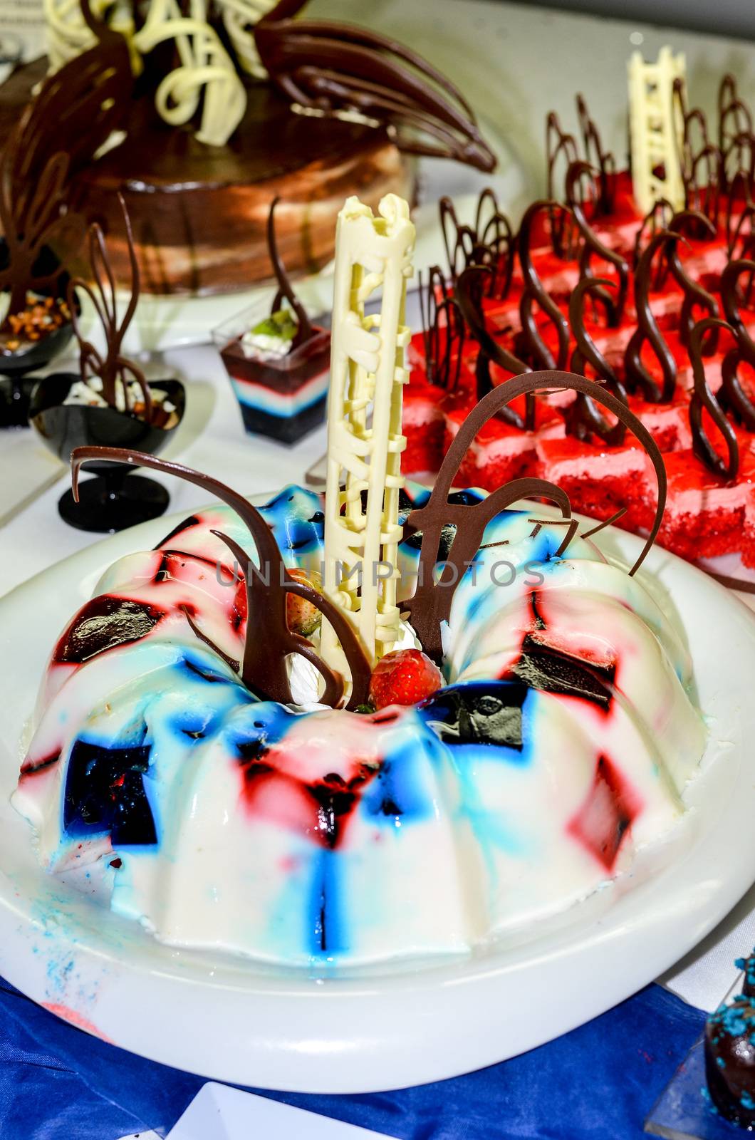 Tray full of cupcakes and slices of cake inside a buffet