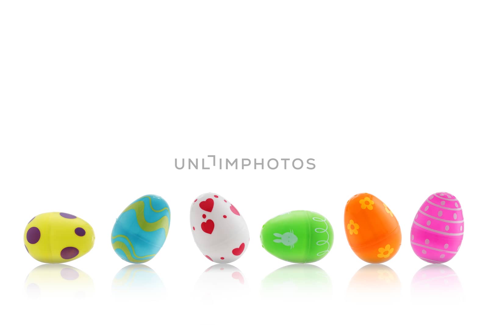 A set of Easter toy eggs on white with reflection