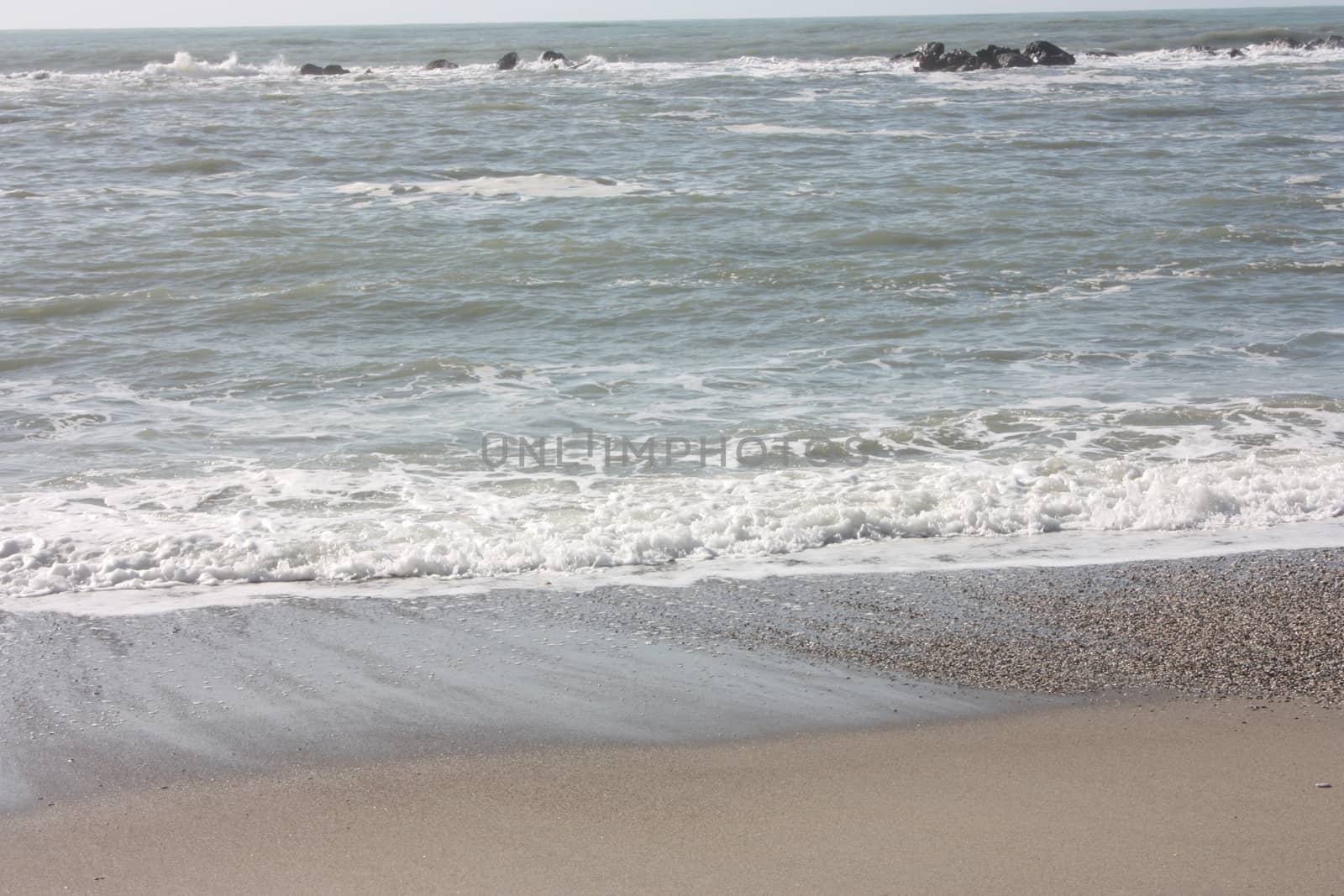 A winter beach with rough seas with cold and dull colors in the Versilian Riviera in italy