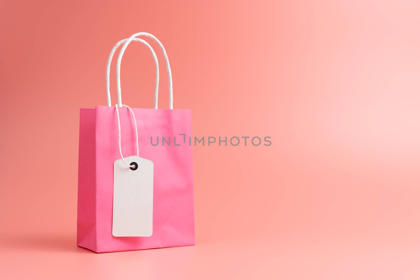 Single pink shopping or gift bag isolated on pink background by Kenishirotie